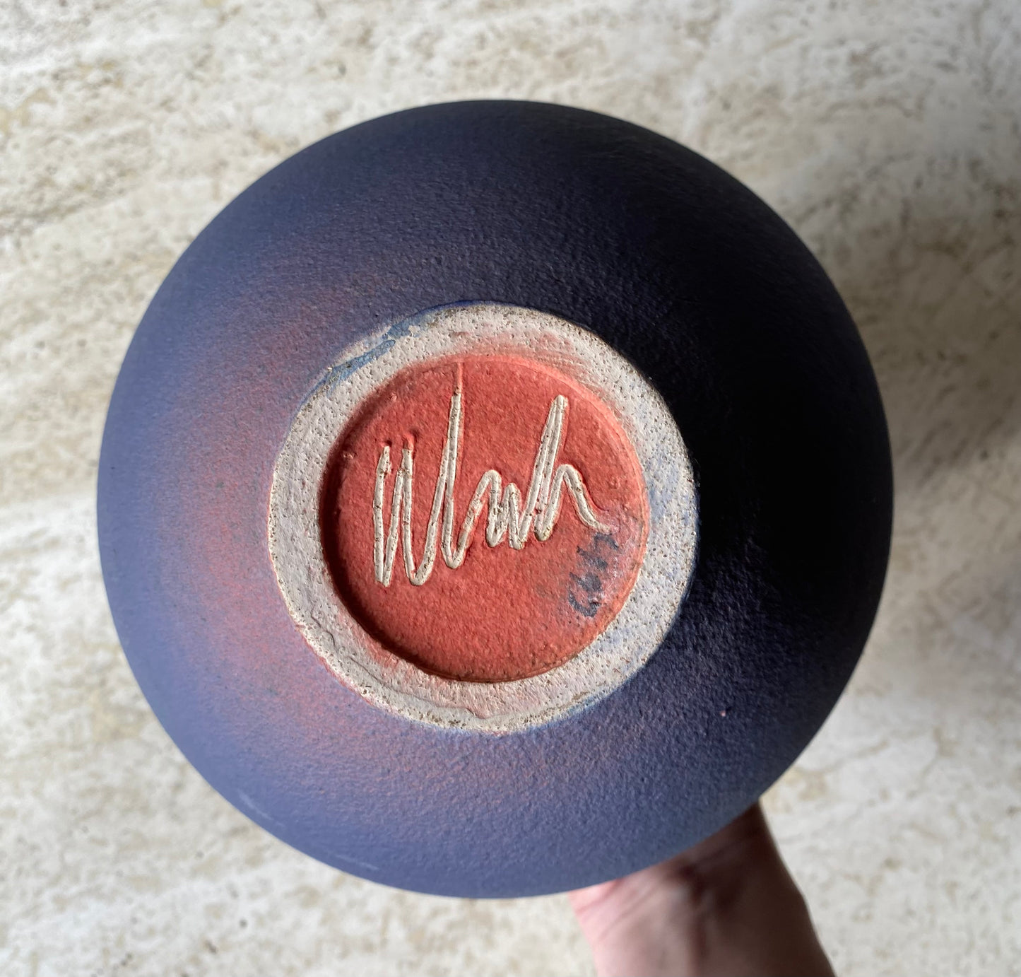 Ceramic bowl with a textured surface and 'Wish' inscription on a light background