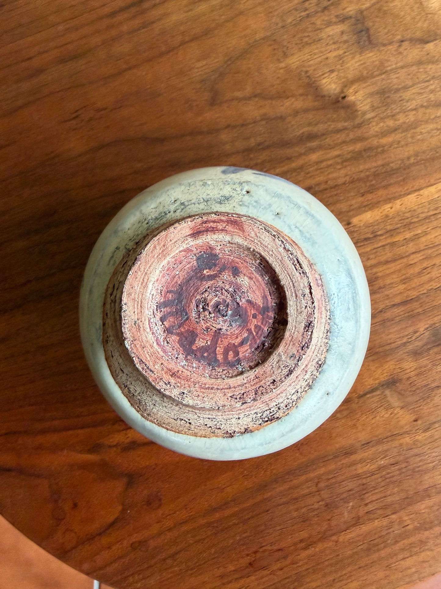 Ceramic vase with a textured base on a wooden surface