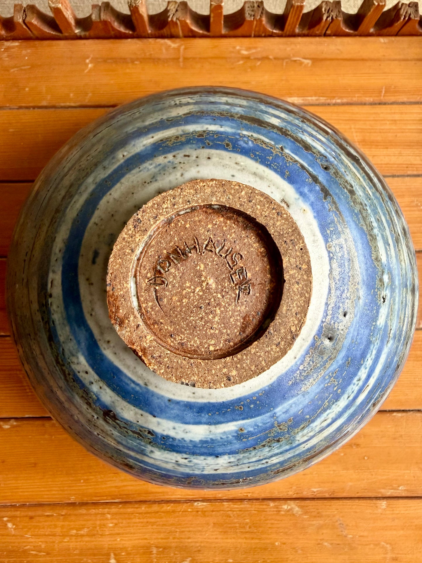 Ceramic bowl with blue interior and brown exterior on a wooden surface
