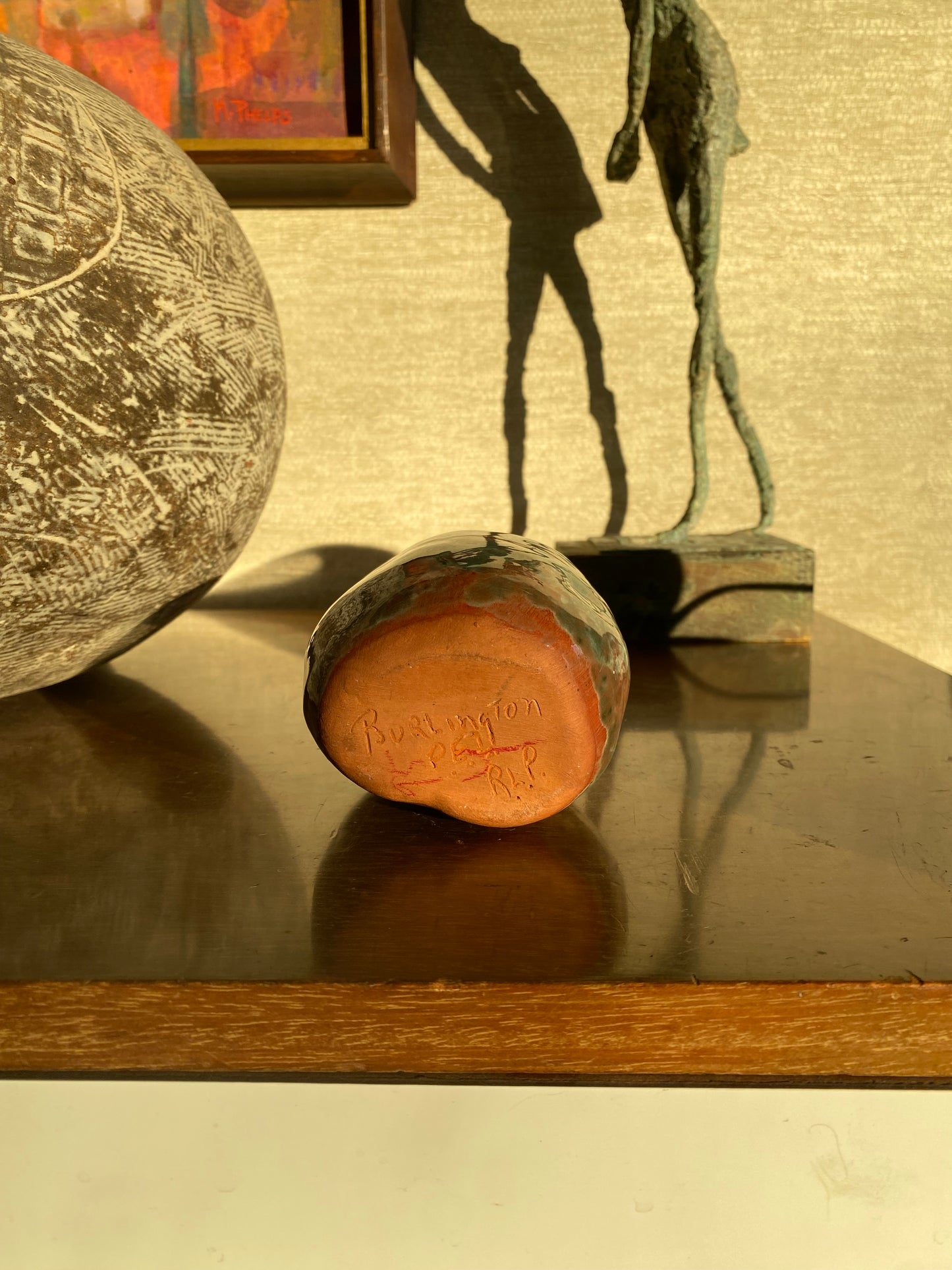 Decorative objects with engraved designs on a textured wall.