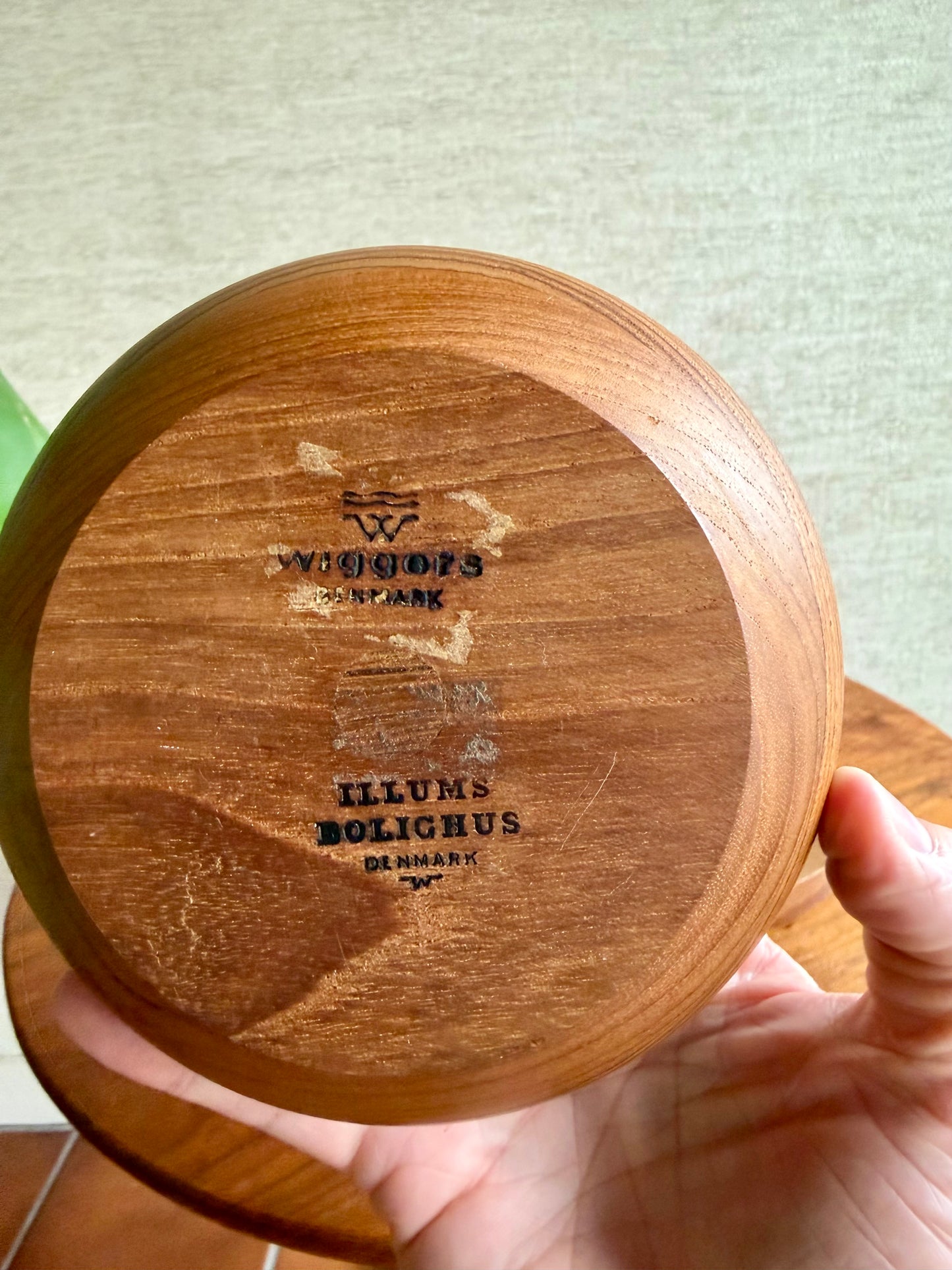 Wooden product with 'Illums Bolighus Denmark' branding held by a hand.