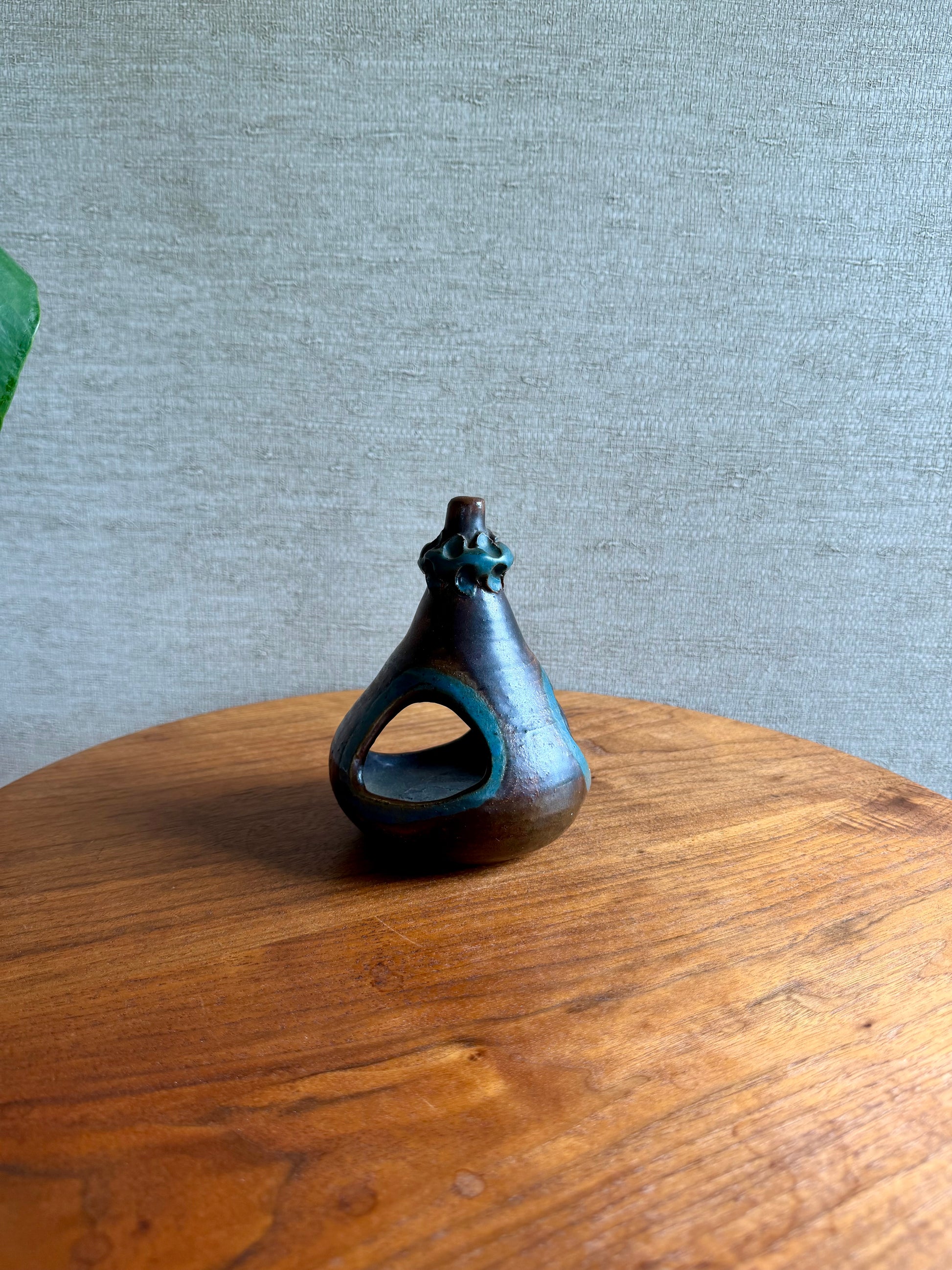 Small ceramic bottle on a wooden surface with a gray textured background