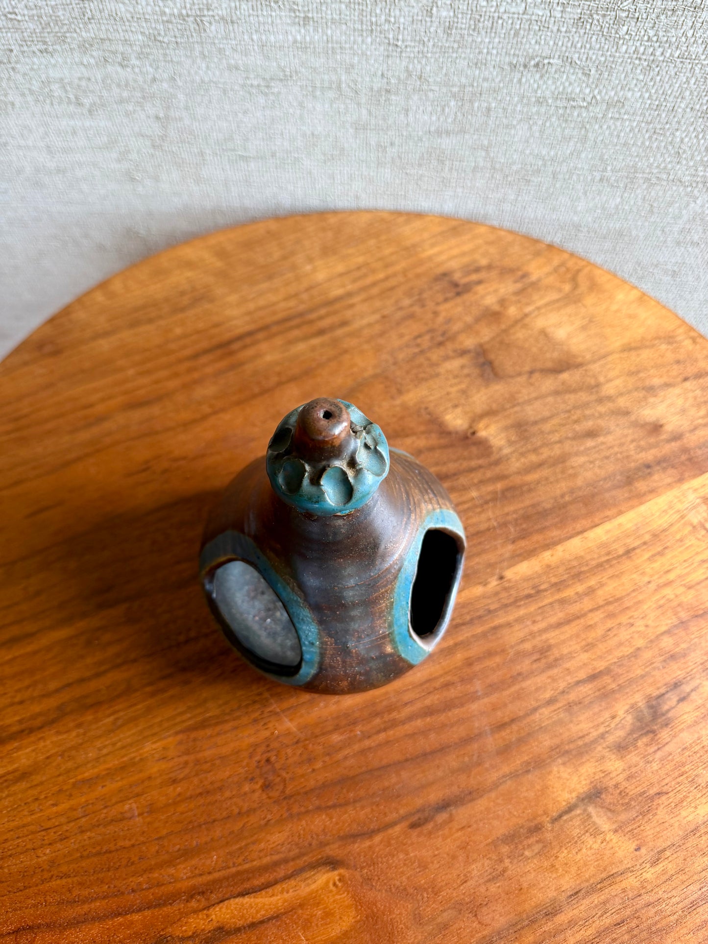 Small ceramic vase with a textured surface on a wooden surface