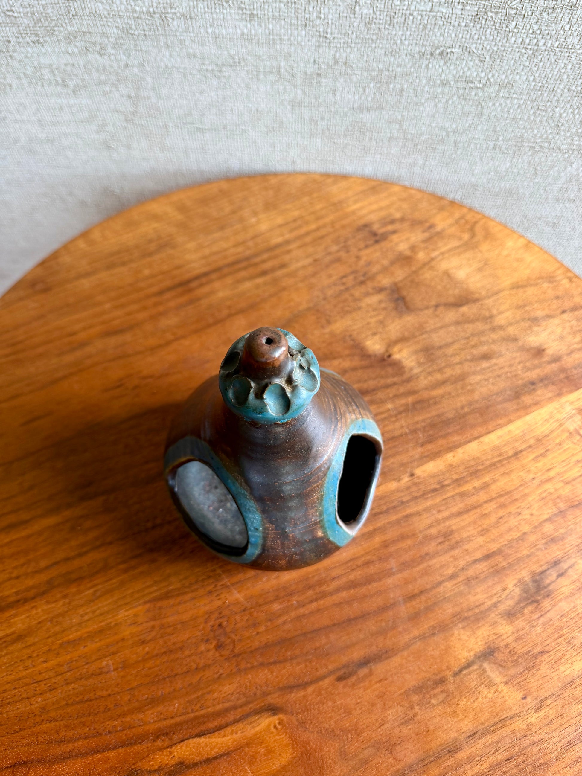 Small ceramic vase with a textured surface on a wooden surface