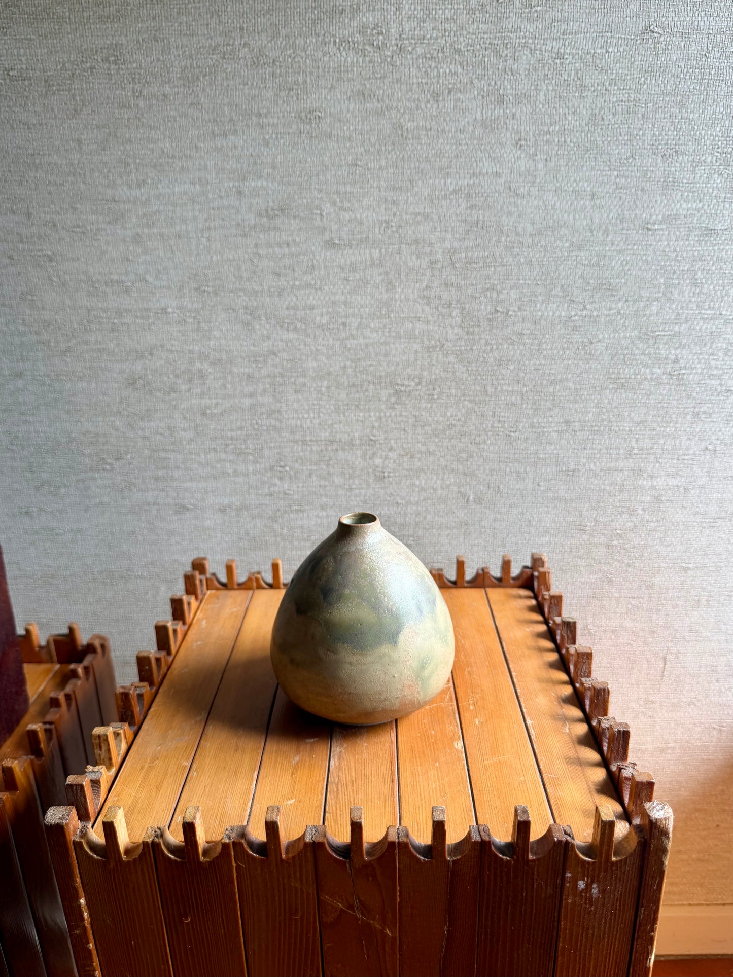 Vase on a wooden table with a textured wall background