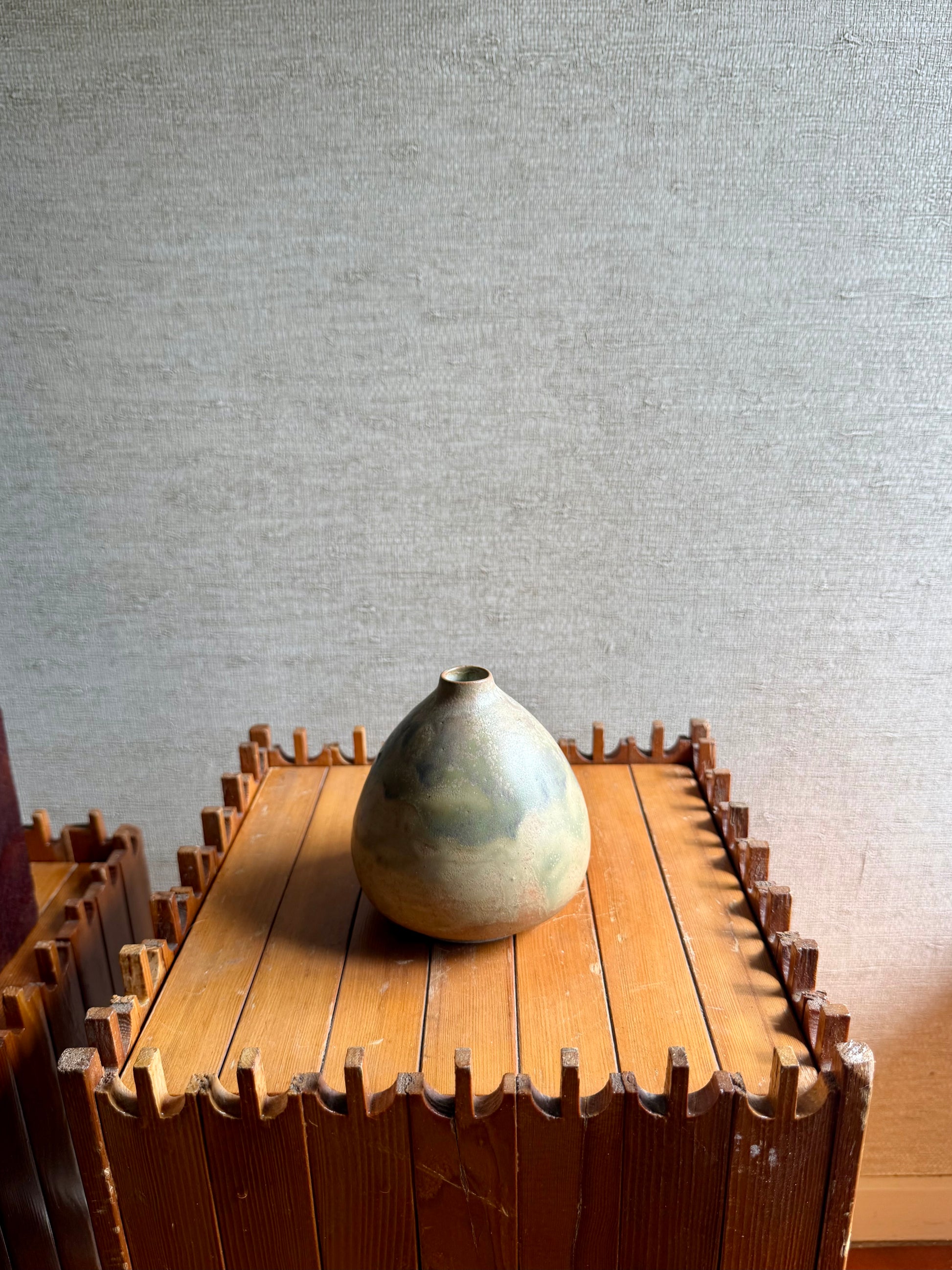 Vase on a wooden table with a textured wall background