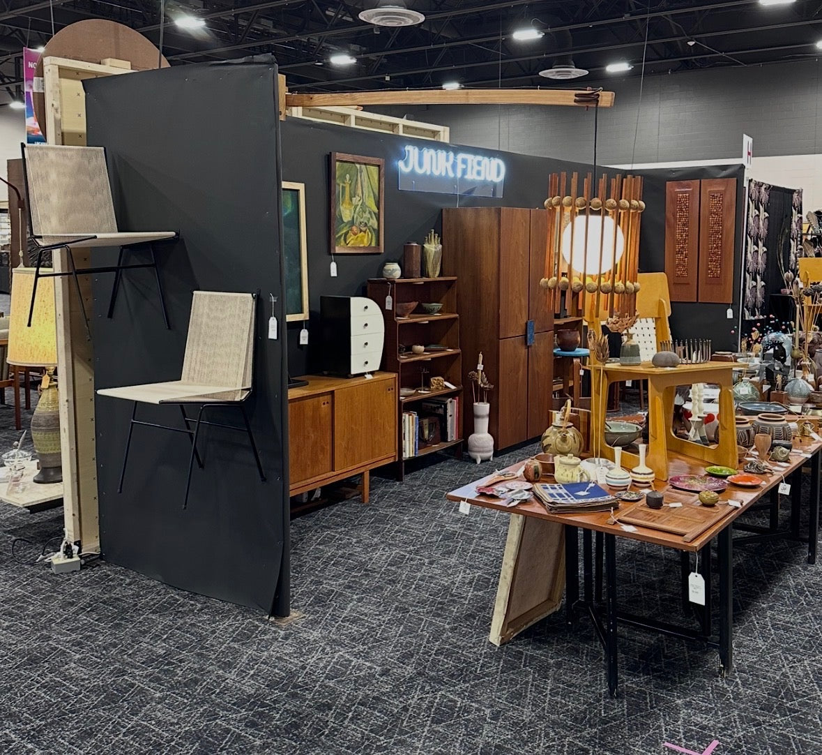 Vintage furniture and decor items displayed at a flea market or antique show.