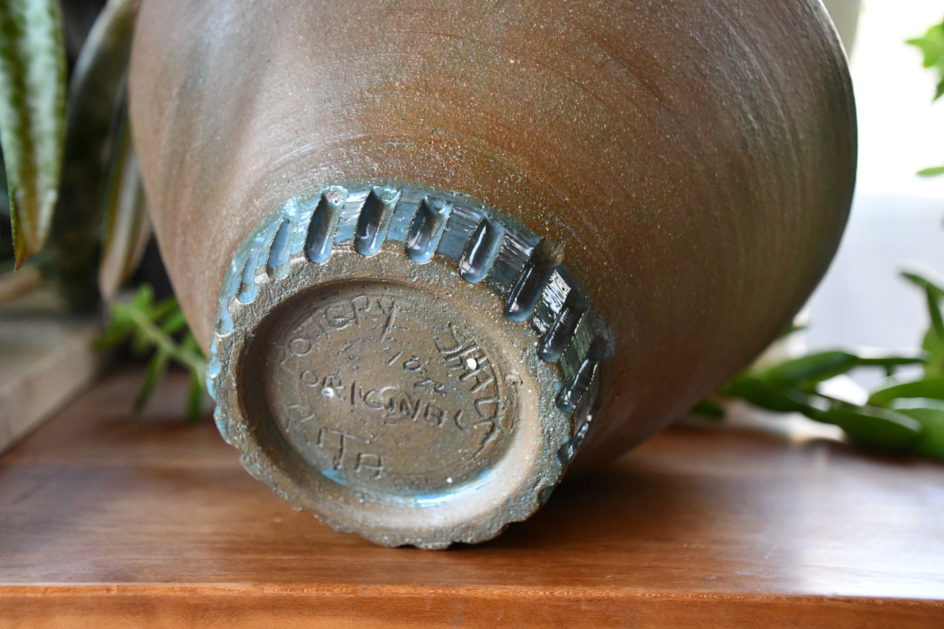 Ceramic vase with a textured base on a wooden surface