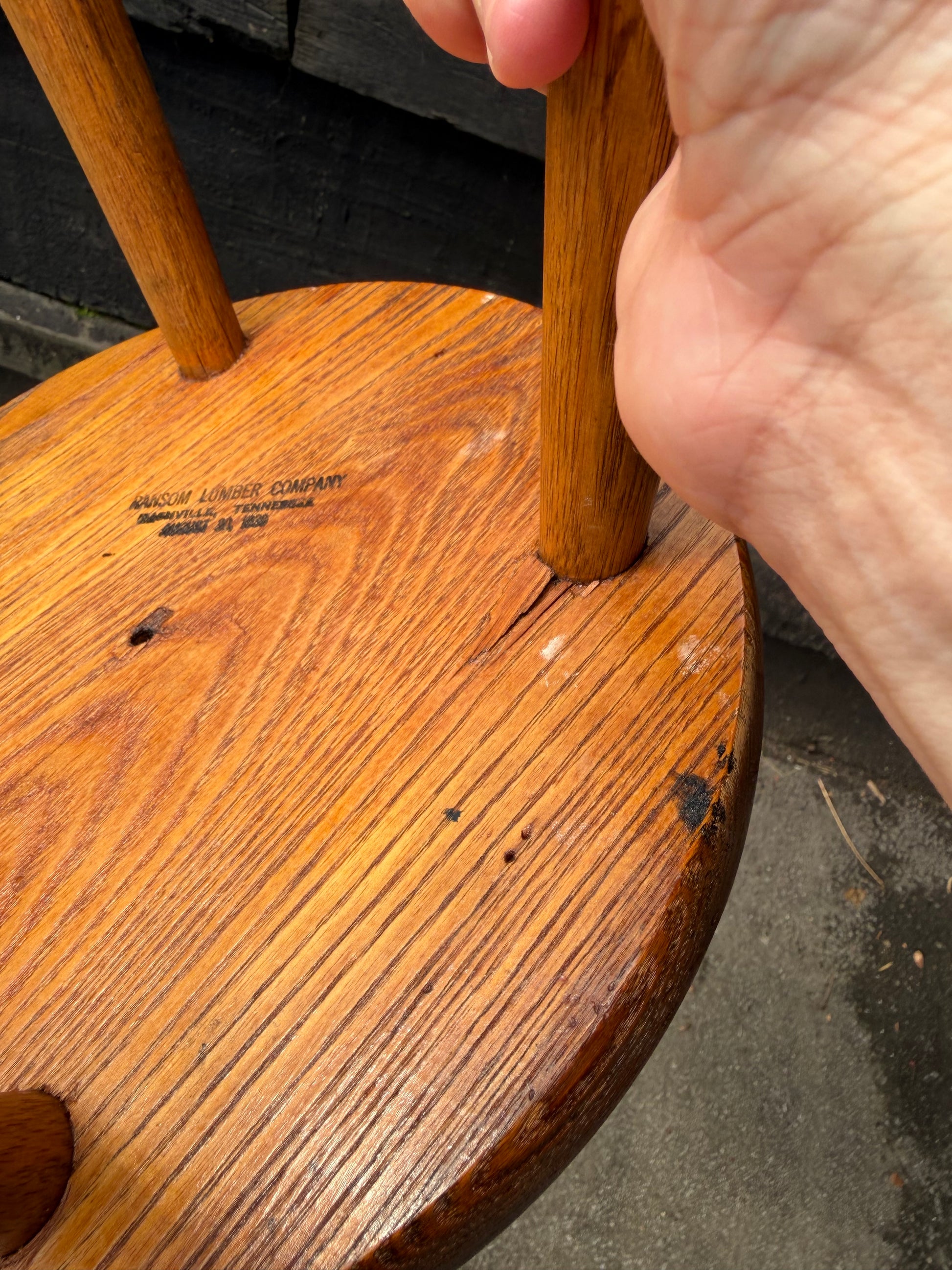 Close-up of a wooden object with a hand holding it, on a dark background