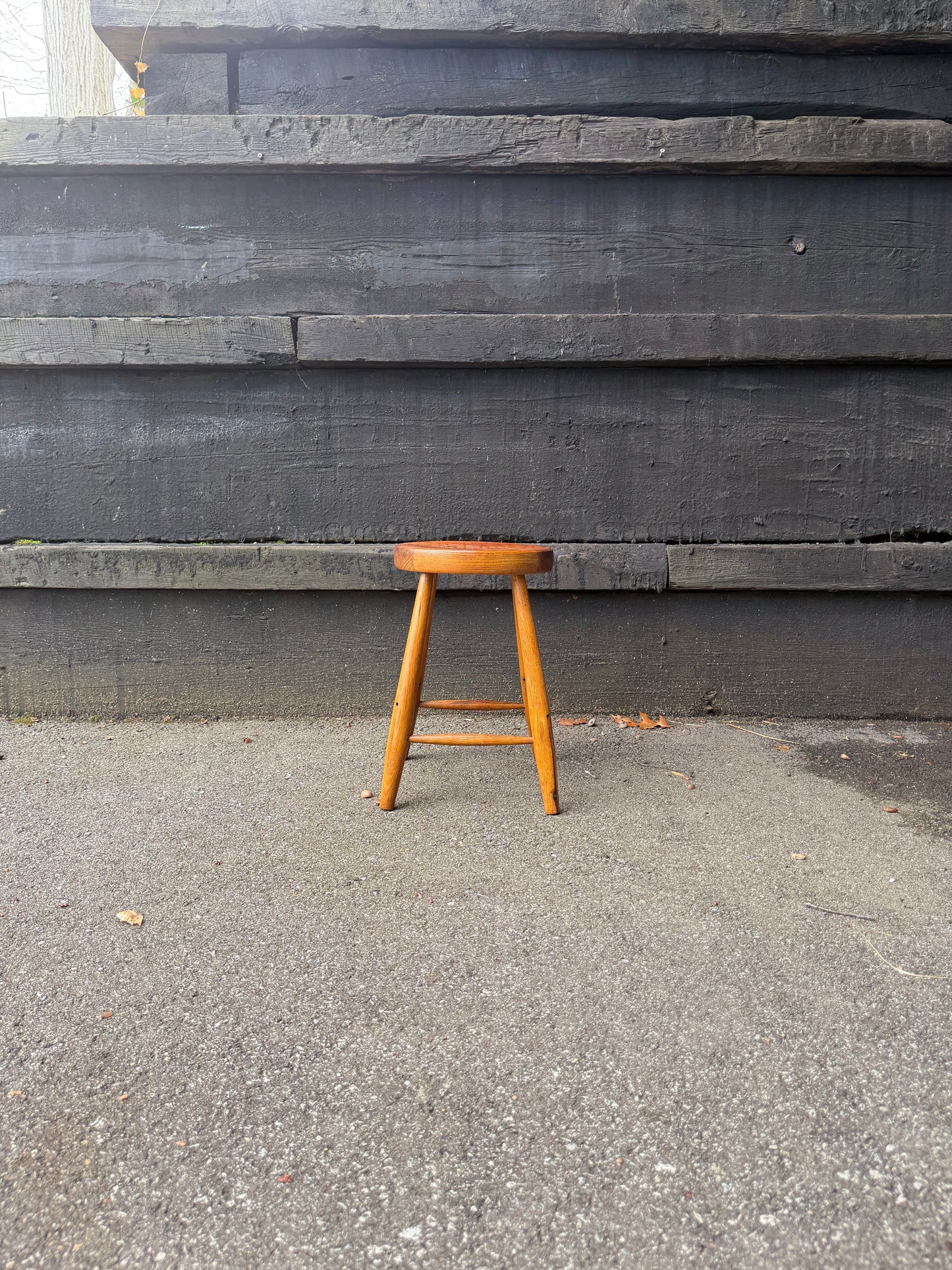 Wooden chair on a concrete surface with a concrete wall in the background