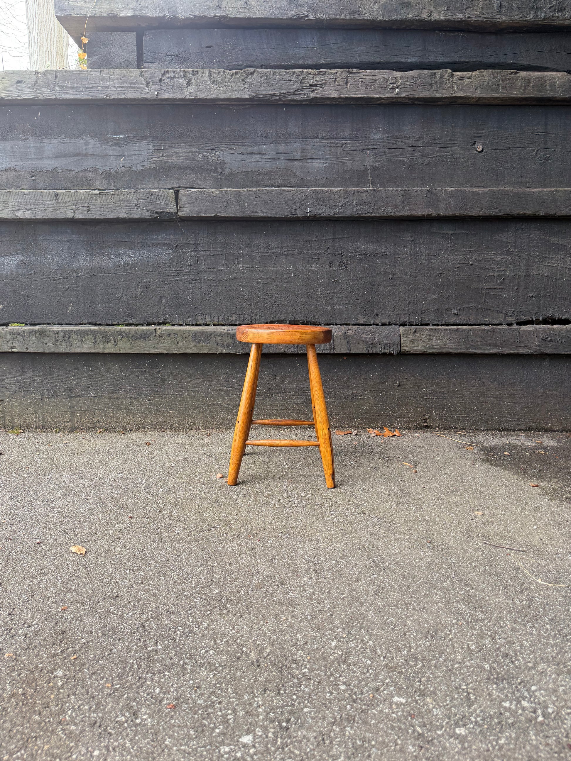 Wooden chair on a concrete surface with a concrete wall in the background