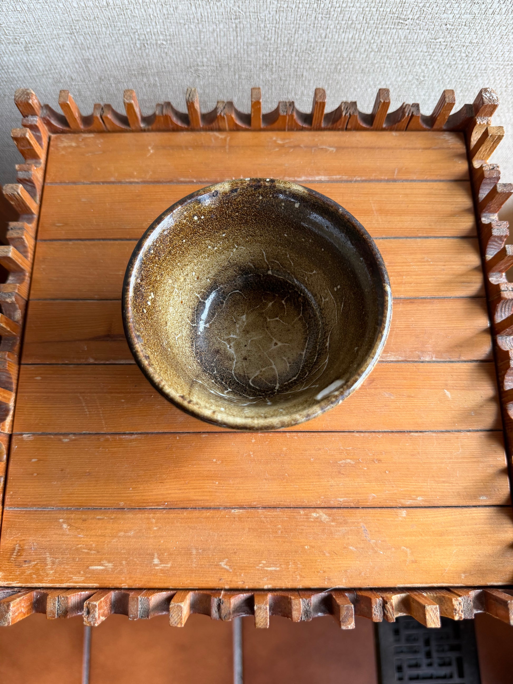 Wooden gear with a ceramic bowl inside on a textured wall background