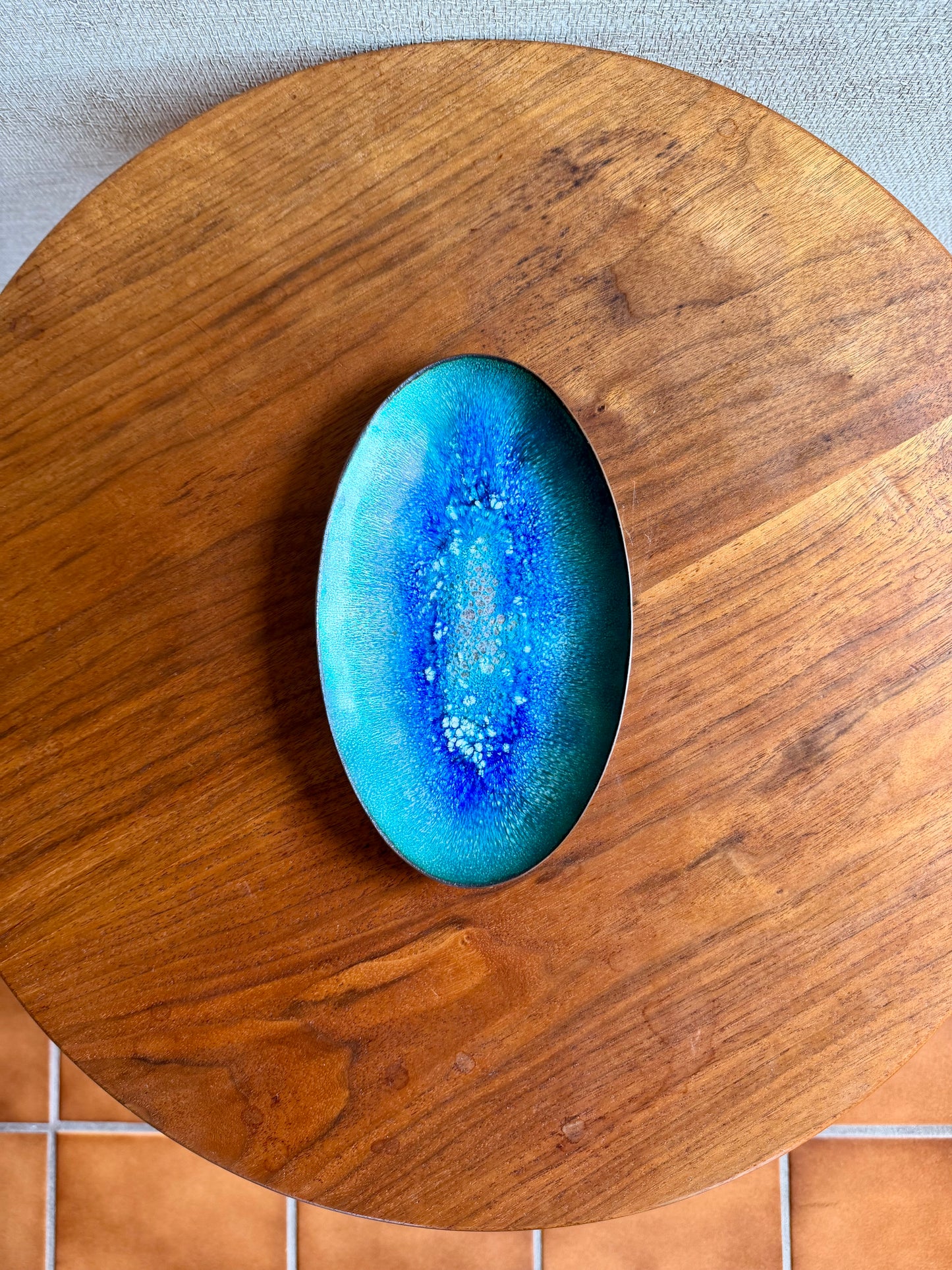 Blue enamel on copper tray on a wooden surface