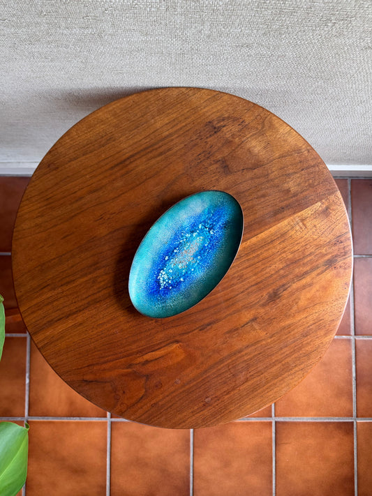 Blue enamel tray on a wooden surface with a tiled floor and wall in the background