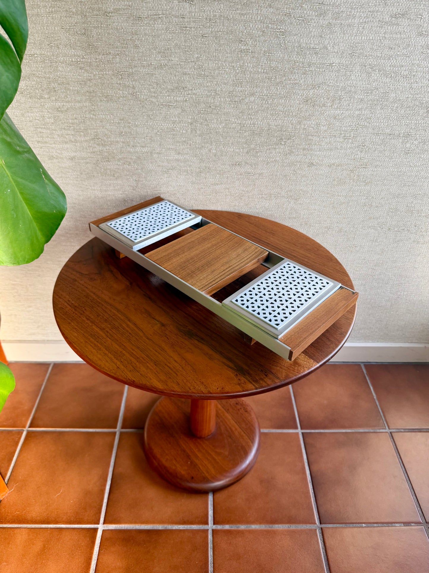 Wooden side table with a plant on a tiled floor