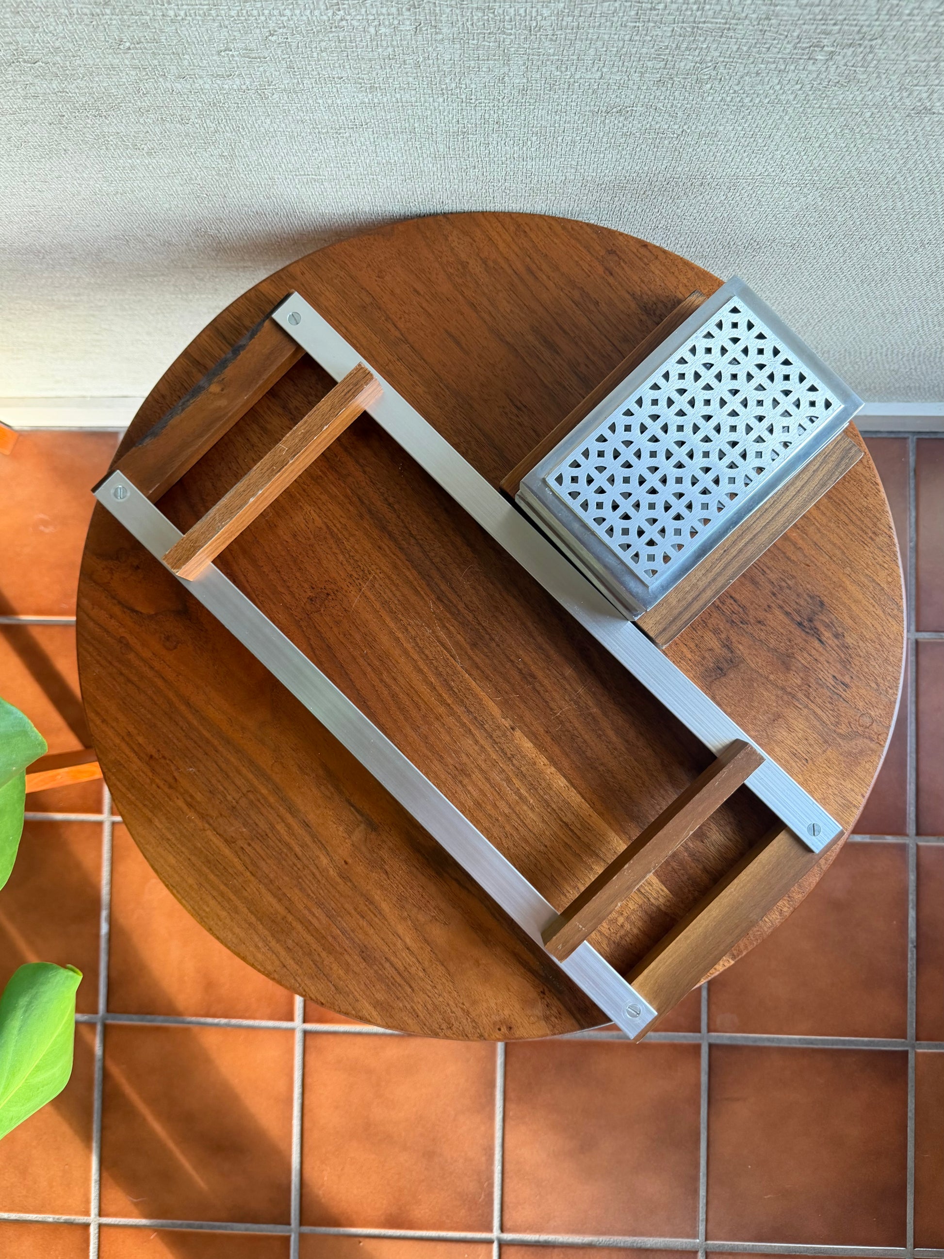 Wooden serving board with metal grater on a tiled surface