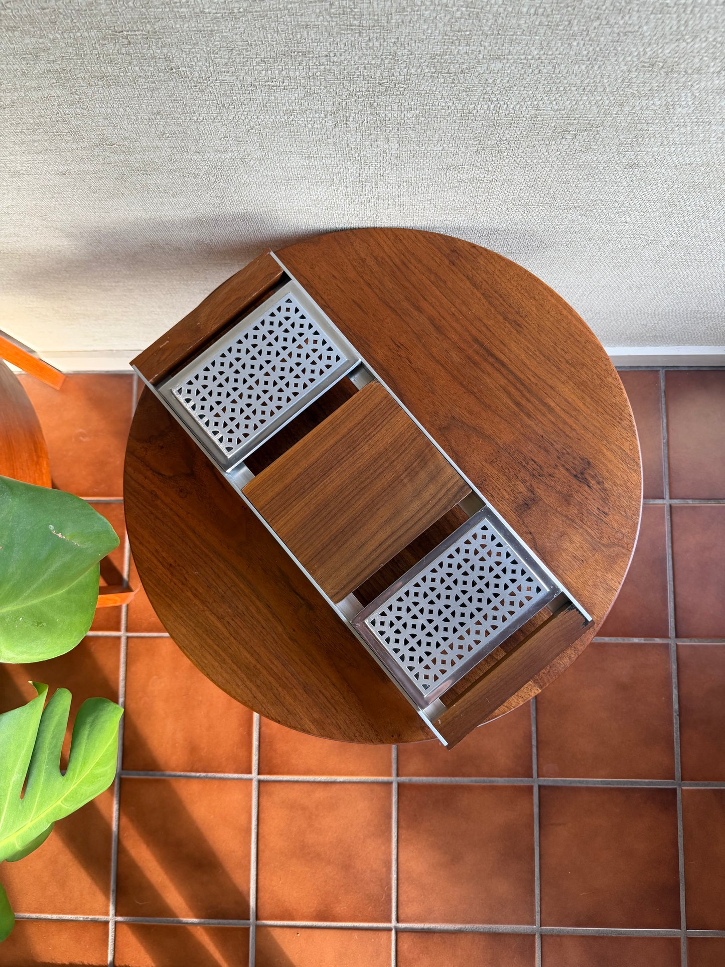 Wooden serving tray with metal grates on a tiled wall
