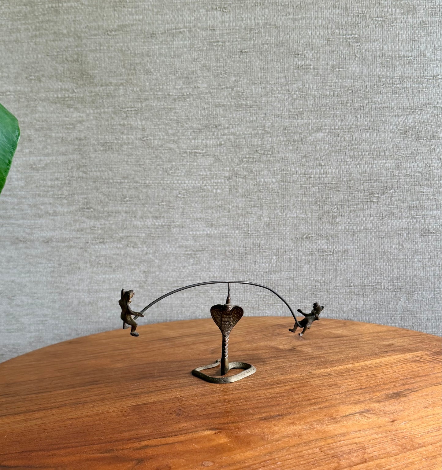 Decorative metal sculpture of two bears on a heart with a gray textured wall background