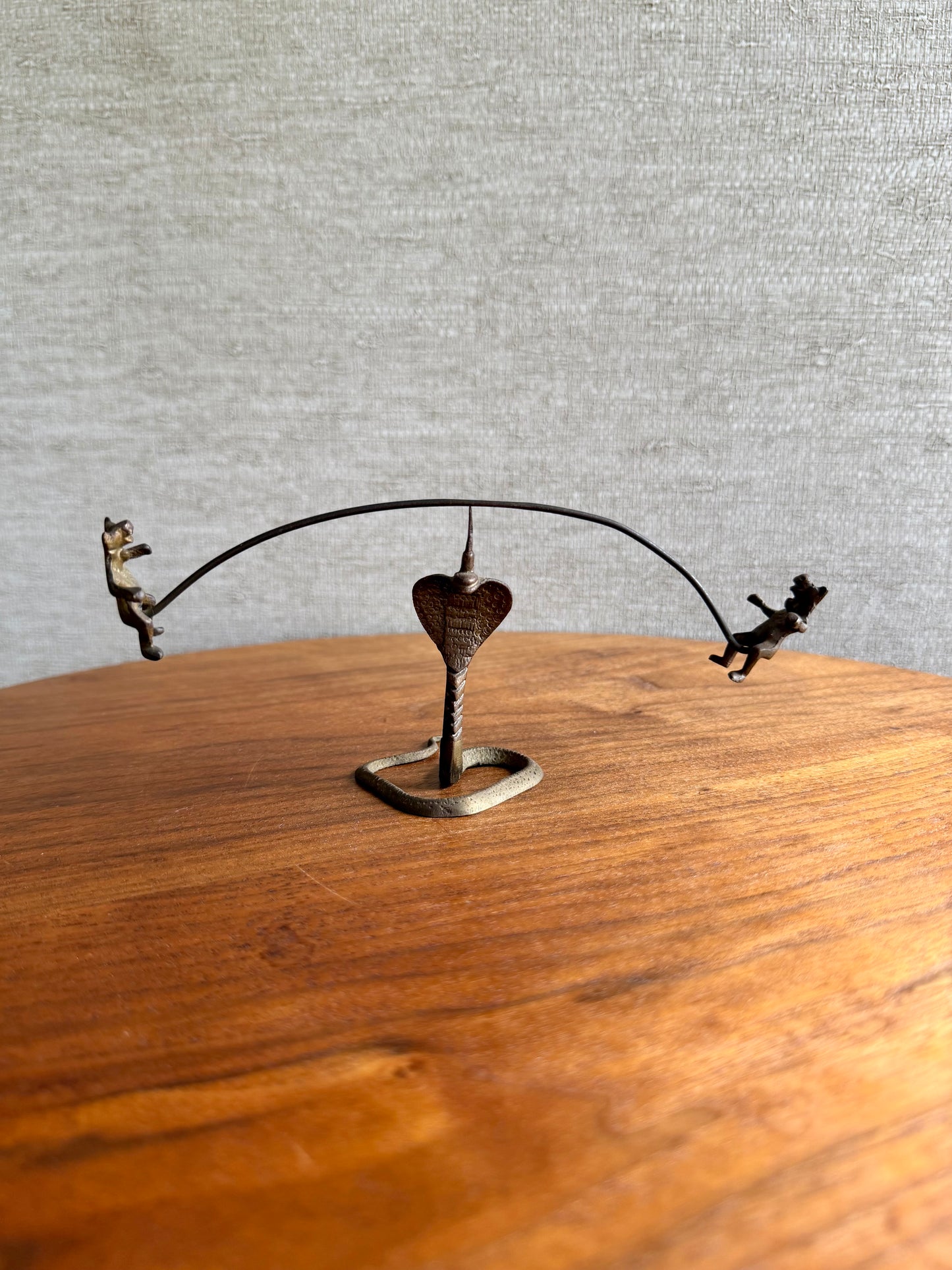 Decorative metal sculpture with a heart on a wooden surface