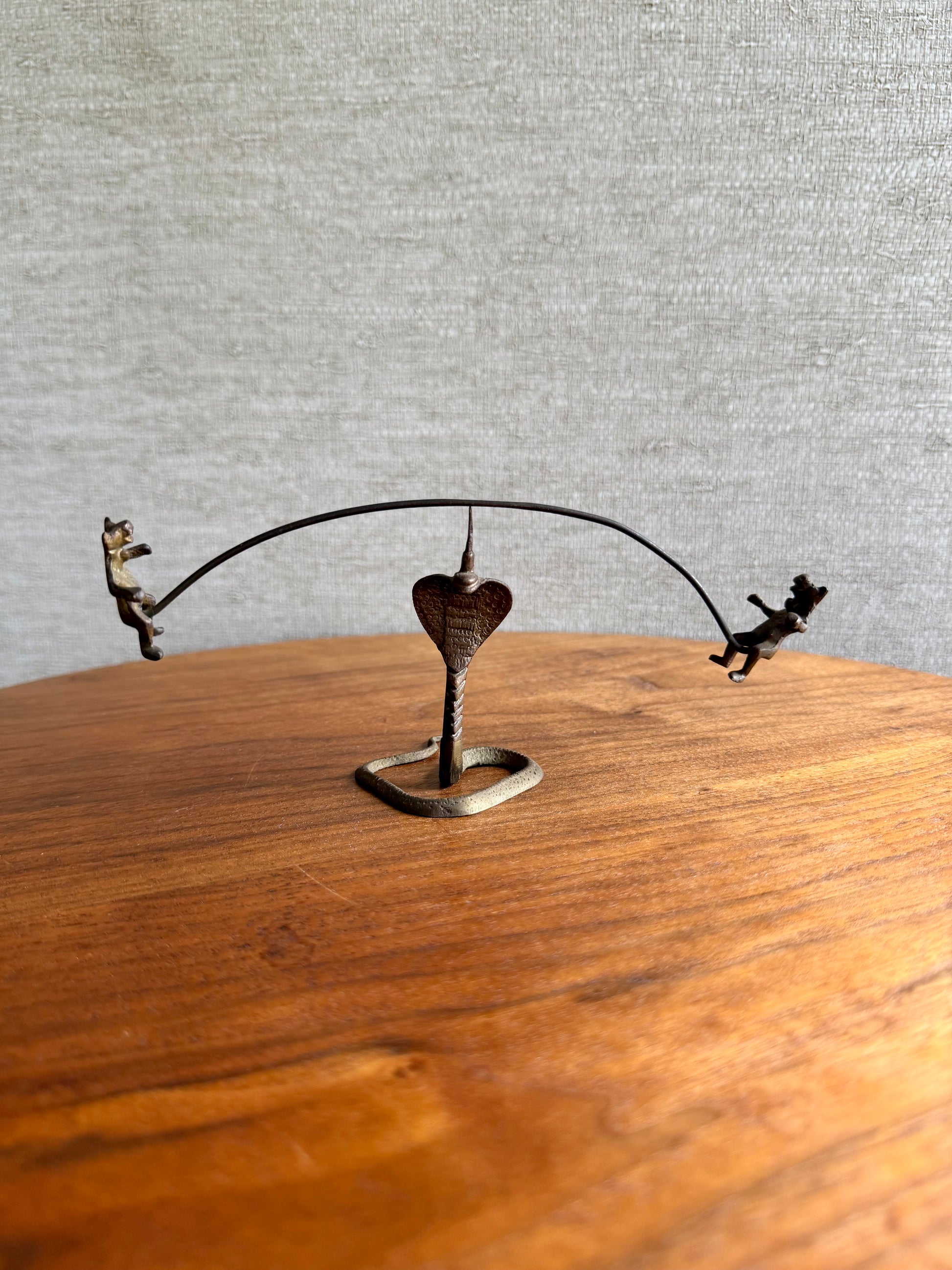 Decorative metal sculpture with a heart on a wooden surface