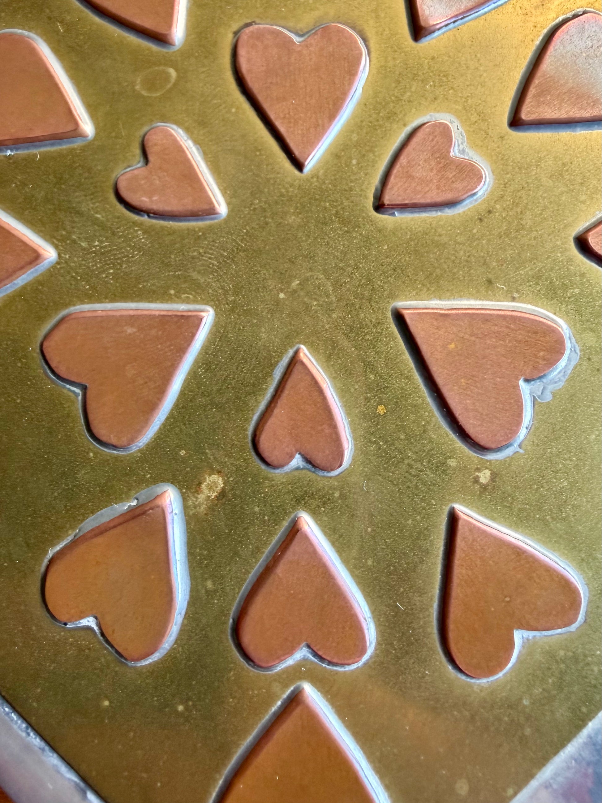 Heart-shaped chocolate molds on a metal surface