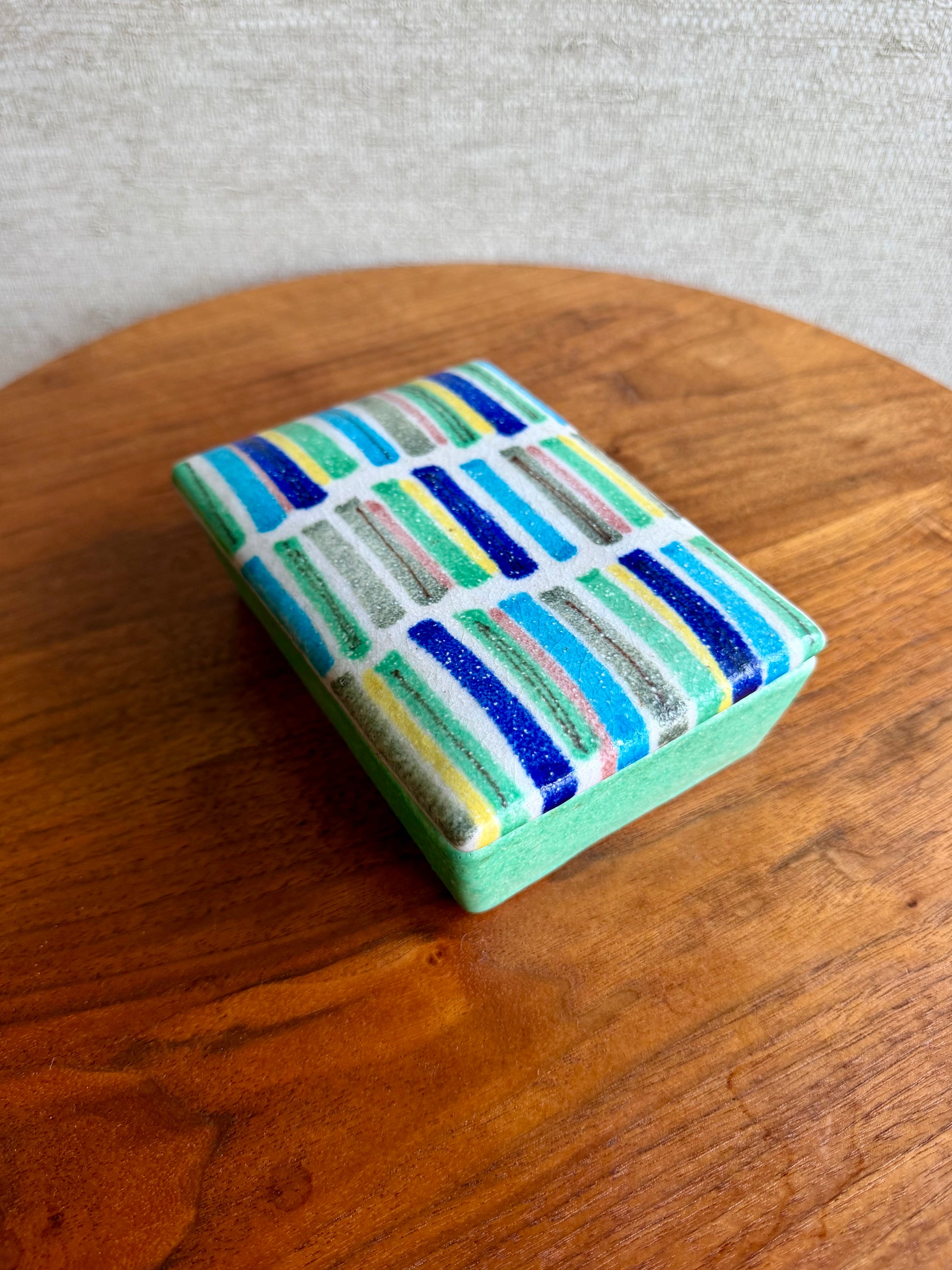 Colorful striped box on a wooden surface with a neutral background