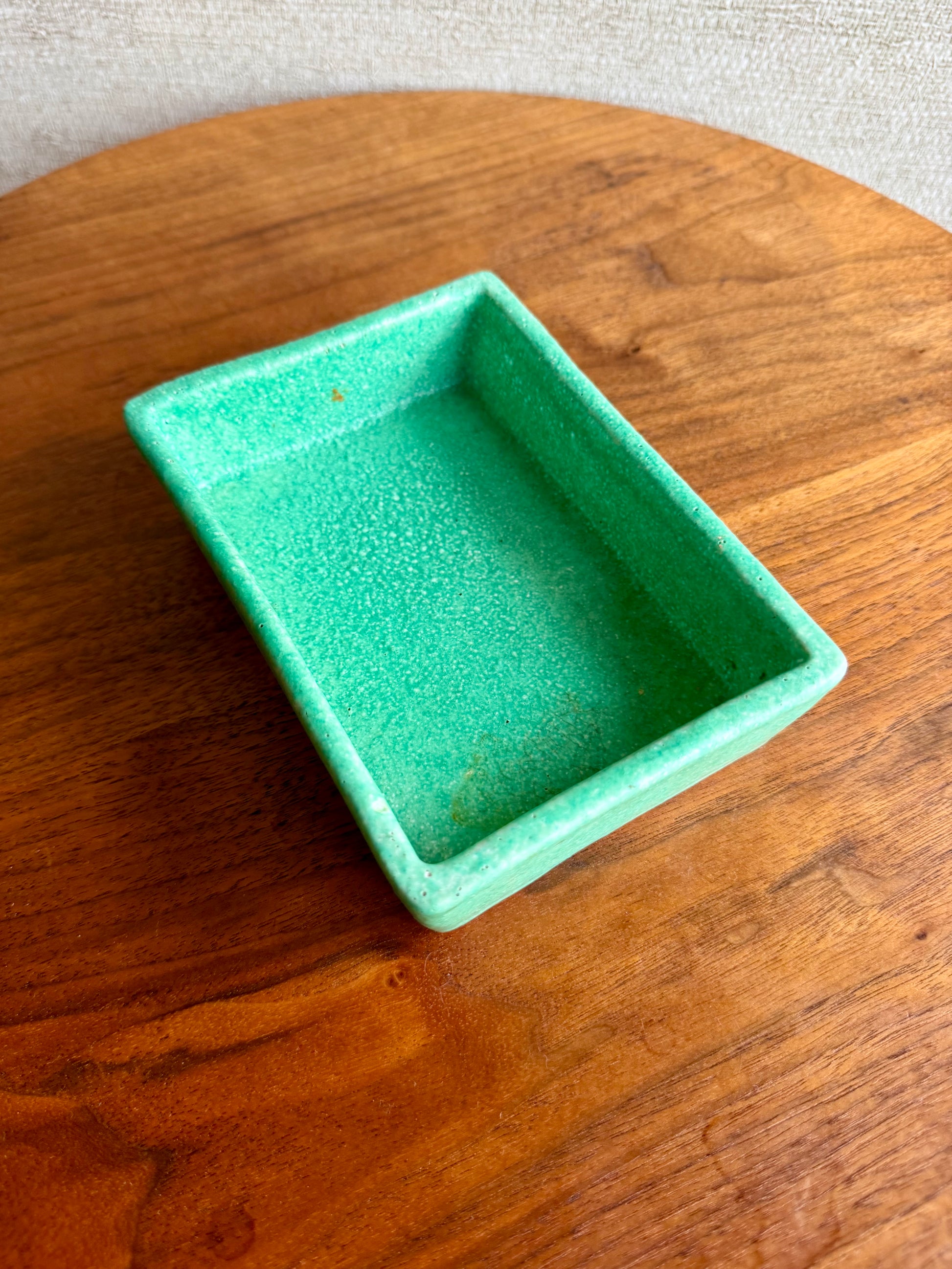 Green ceramic dish on a wooden surface