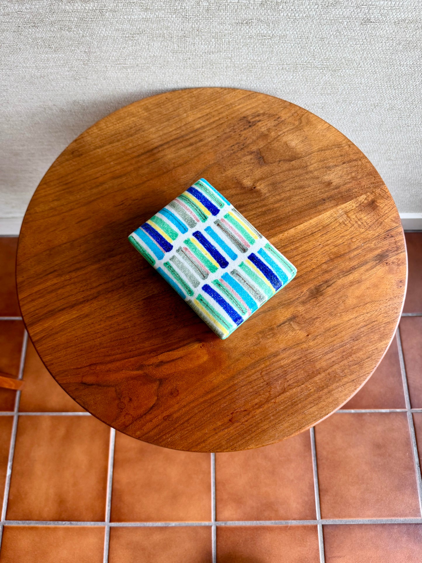 Small rectangular object with a colorful pattern on a wooden table.