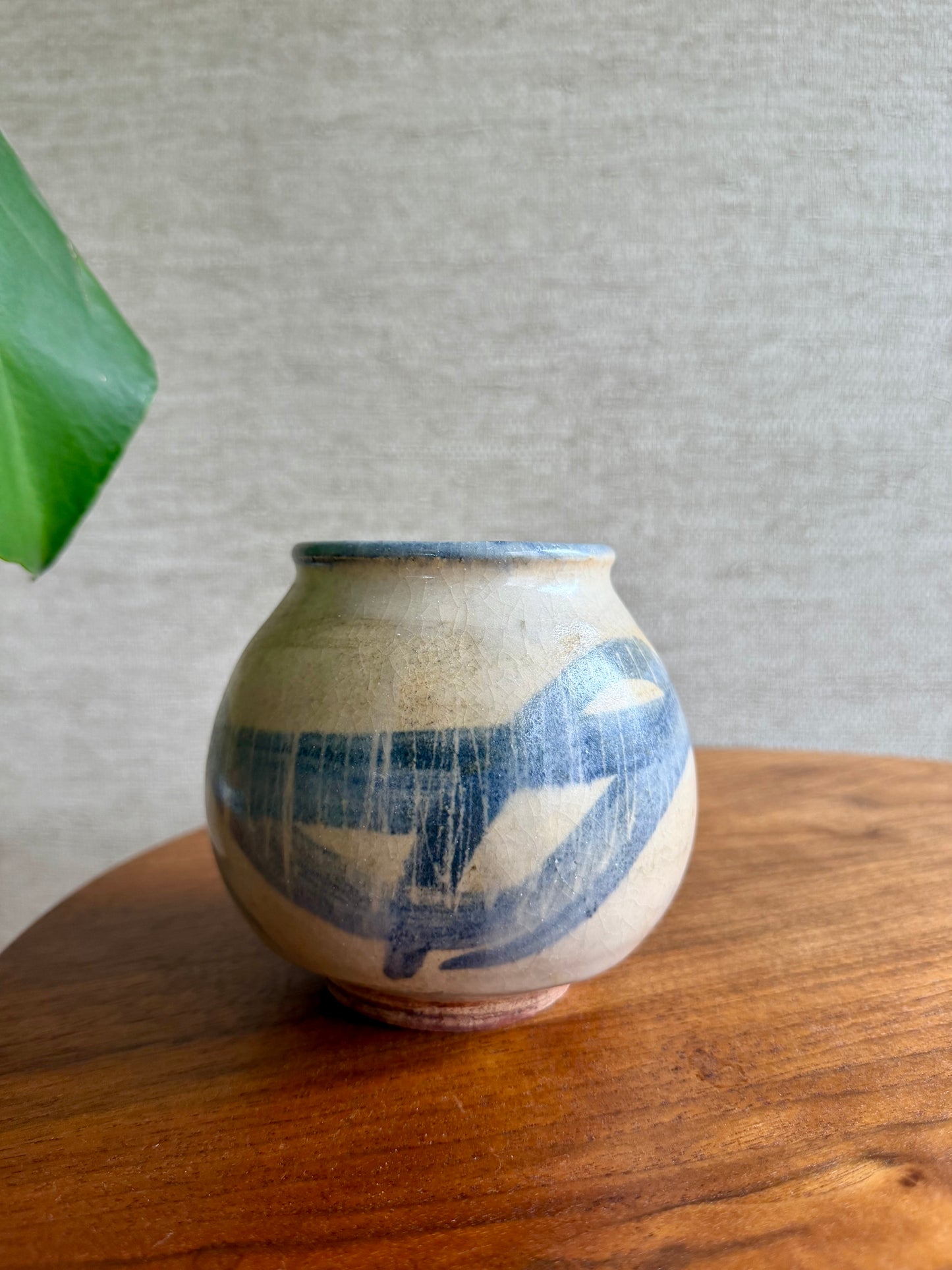 Ceramic vase with blue patterns on a wooden surface