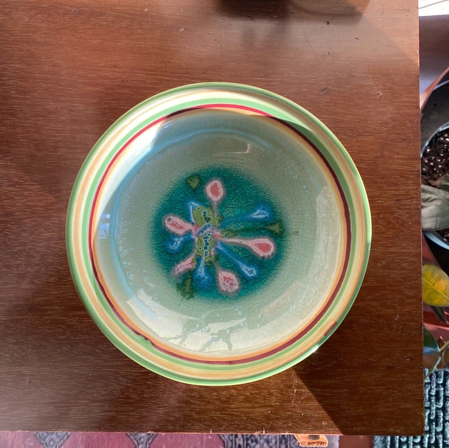 Decorative ceramic bowl with colorful design on a wooden surface