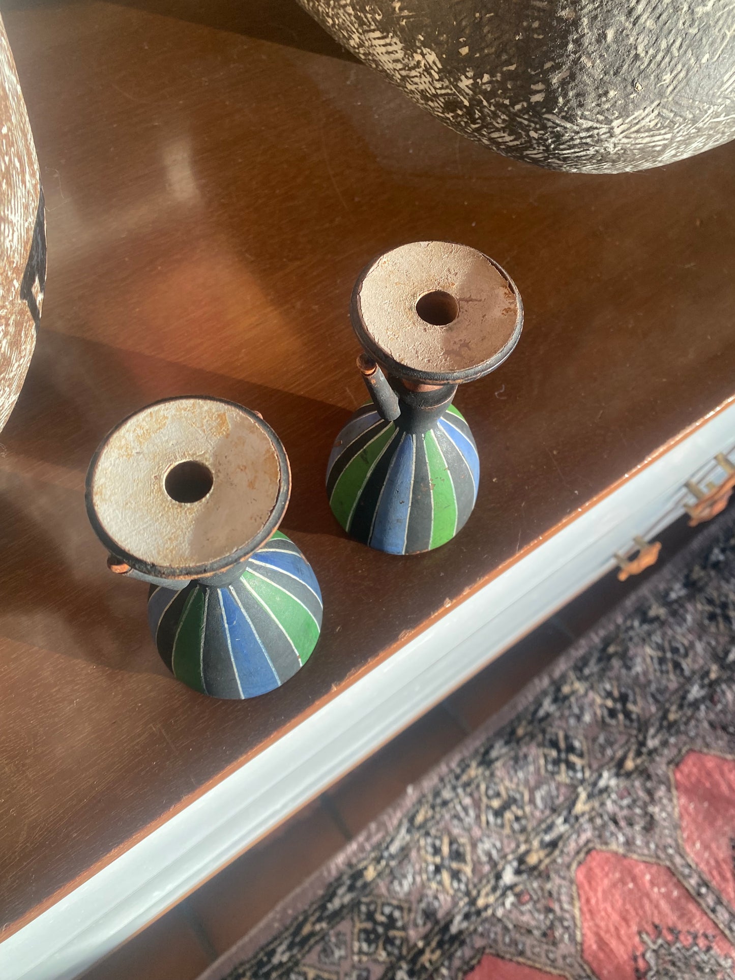 Two decorative knobs with striped design on a wooden surface.