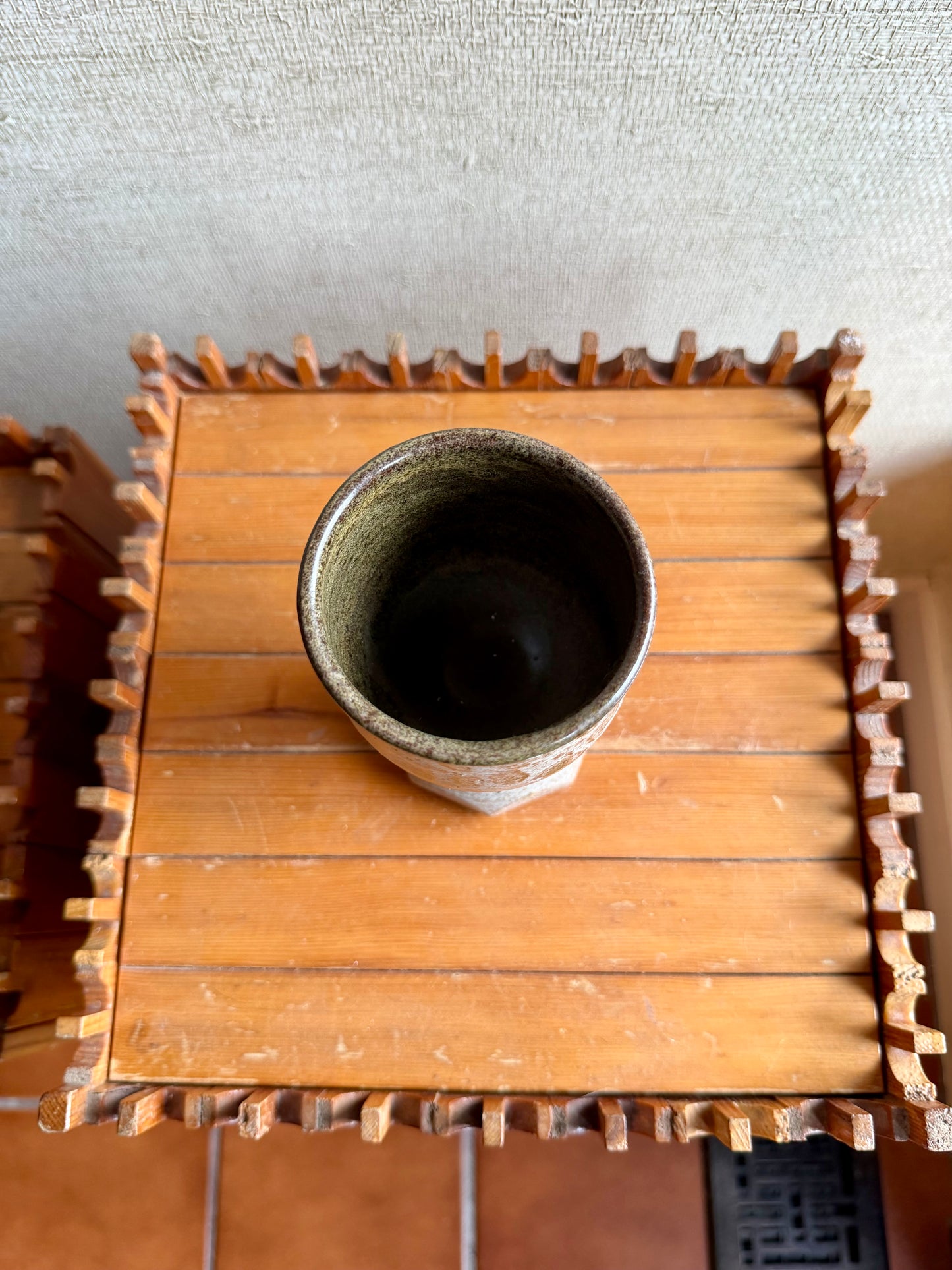 Ceramic cup on a wooden tray with a textured background