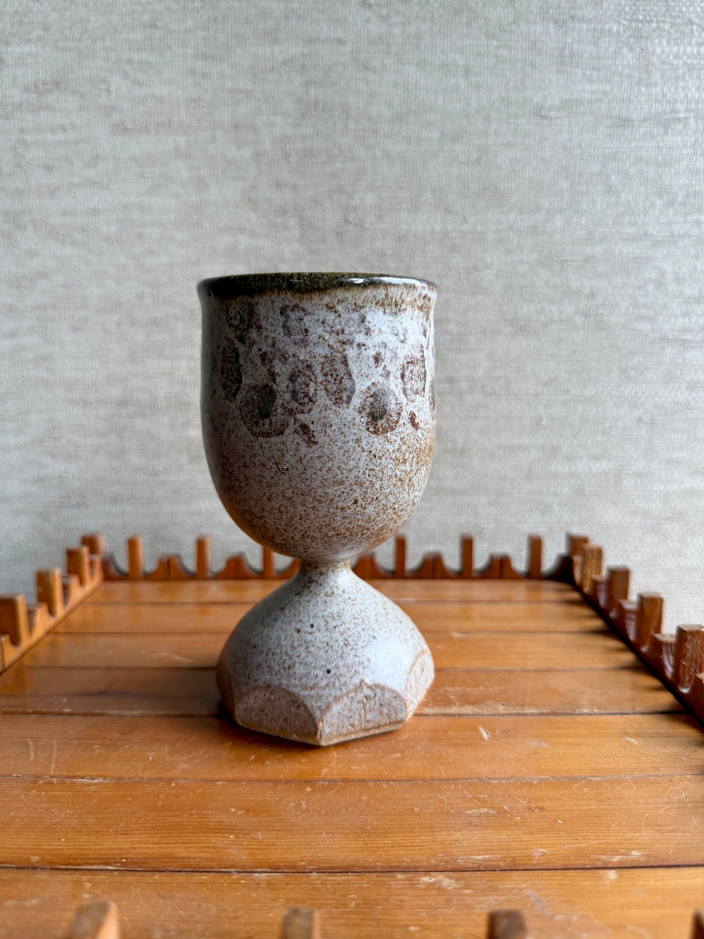 Ceramic cup with textured surface on a wooden surface