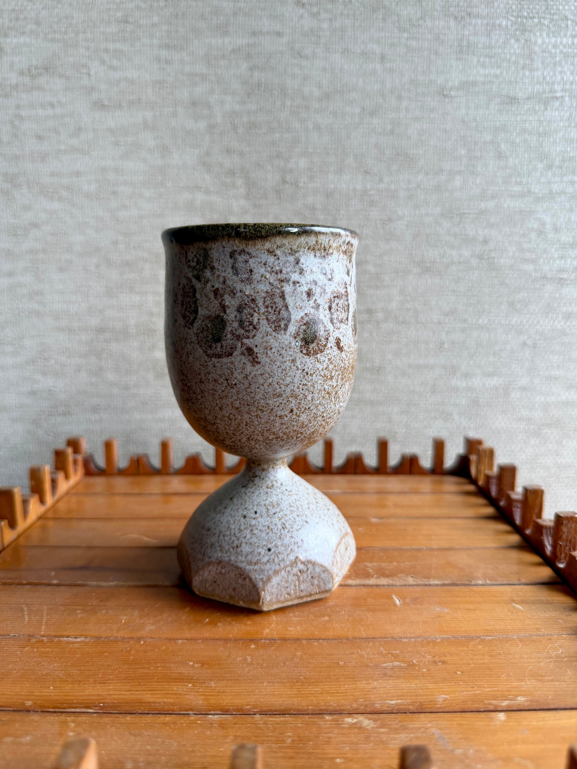 Ceramic cup with textured surface on a wooden surface