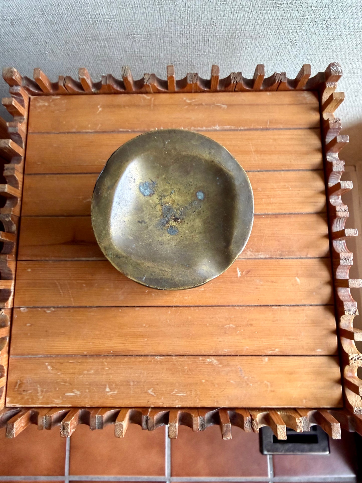 Wooden box with a brass plate inside on a textured surface