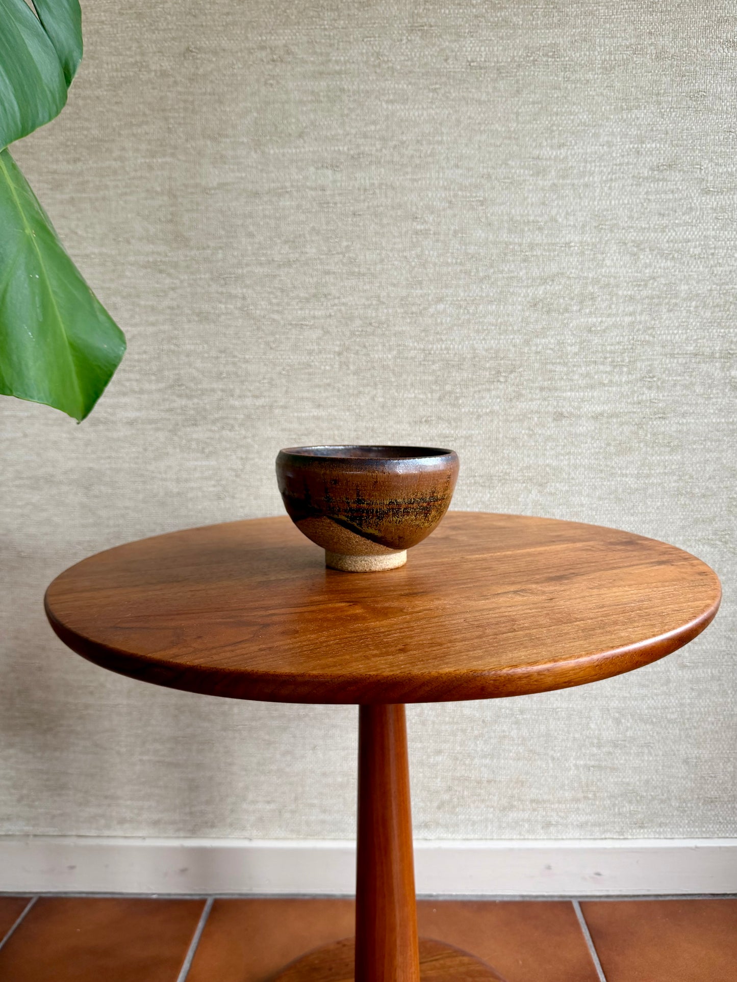 Wooden table with a bowl on a textured wall background