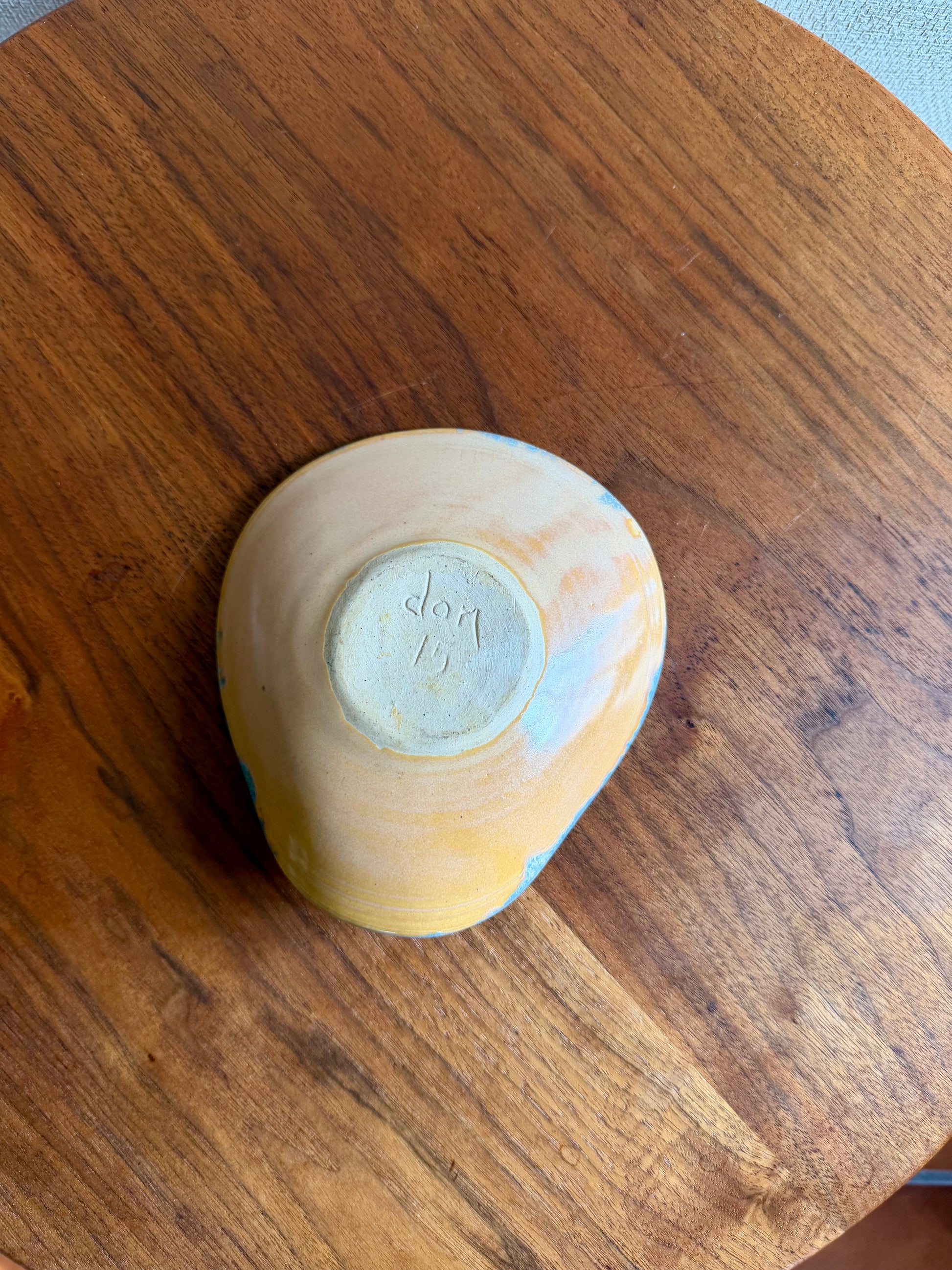 Yellow ceramic bowl with 'Rog' branding on a wooden surface