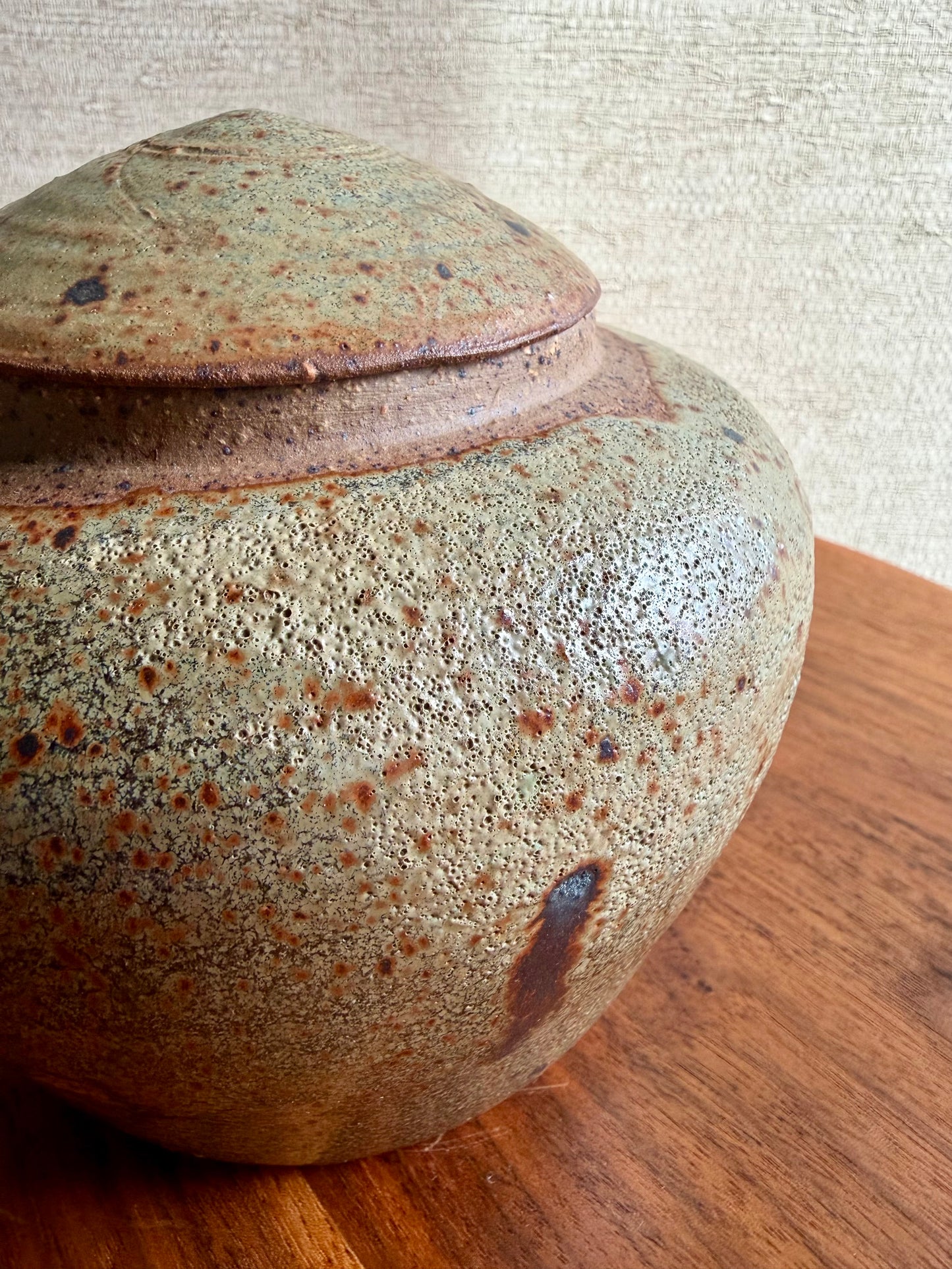 Stoneware jar with a textured surface on a wooden surface