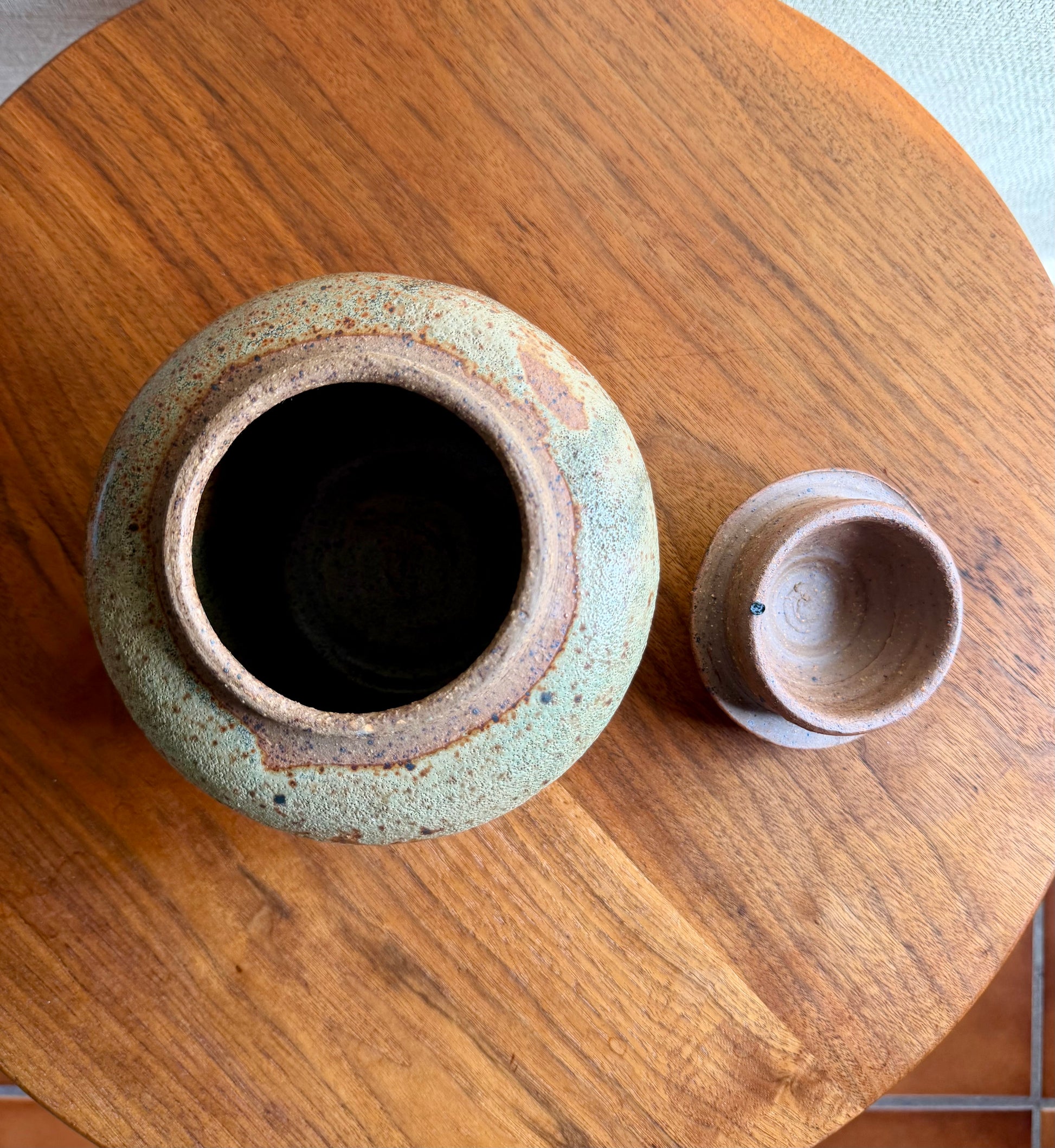 Two ceramic pots on a wooden surface