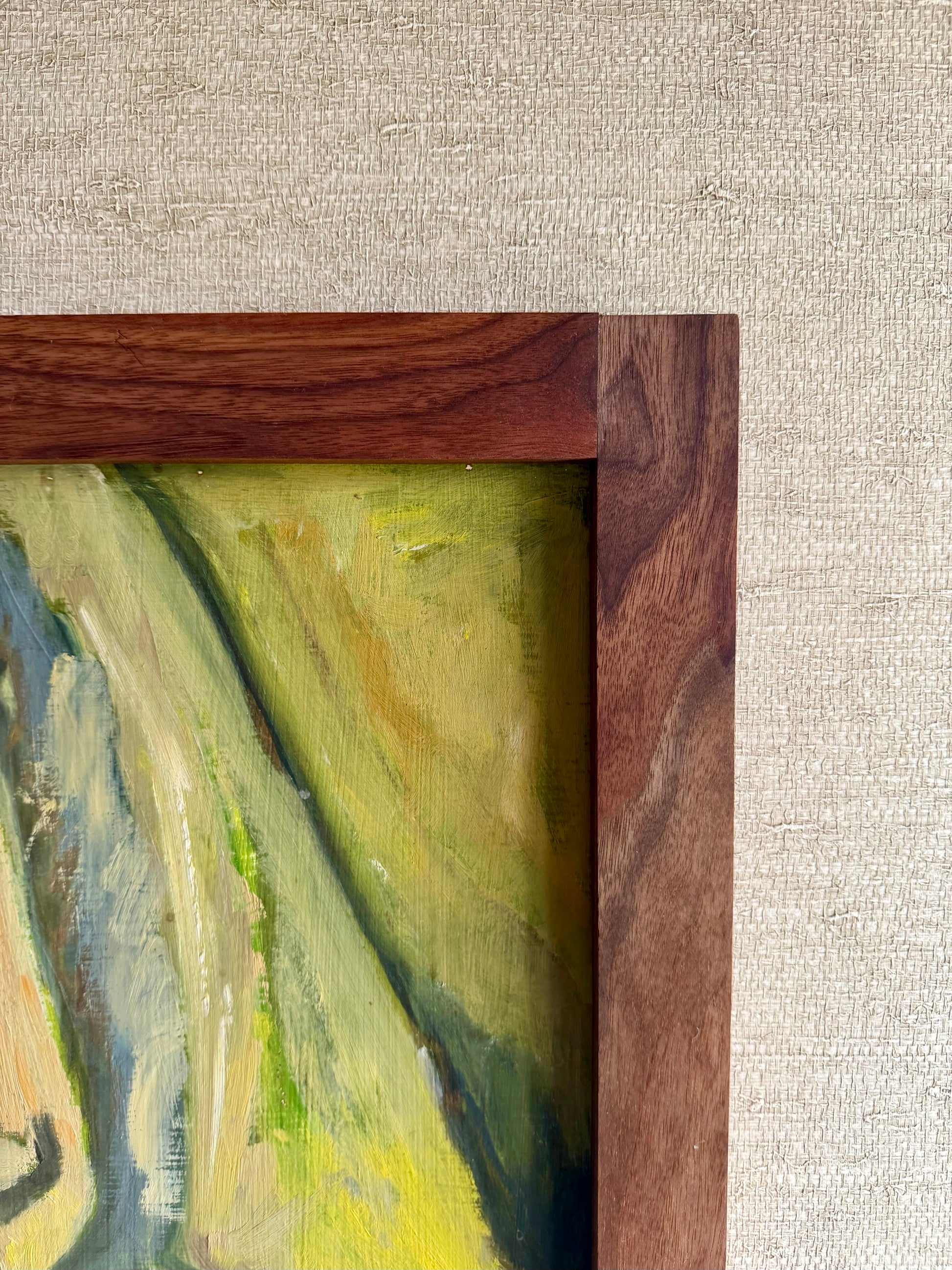 Close-up of a painting with a wooden frame on a textured beige background
