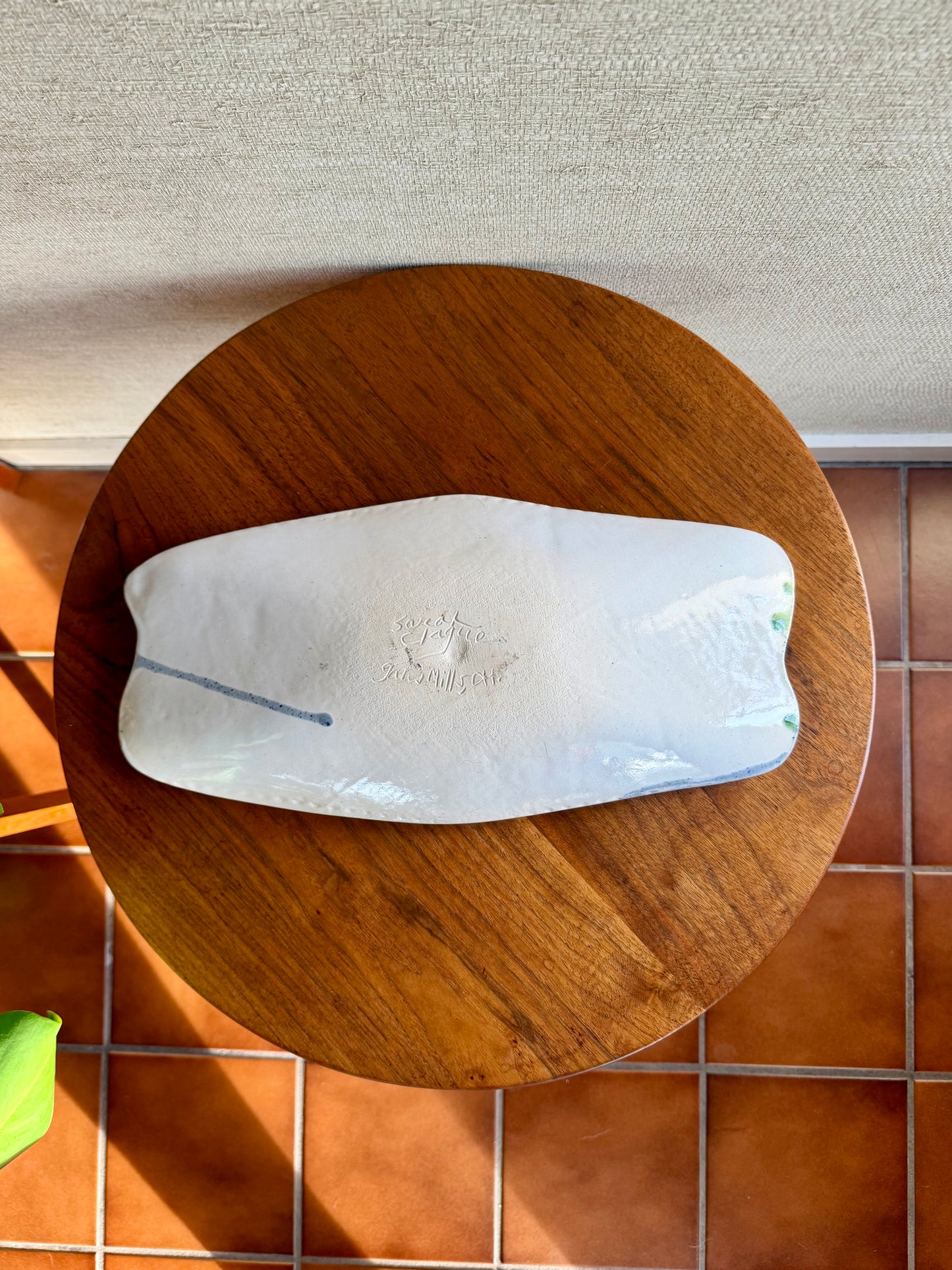 Bottom of white tray on a table with a tiled floor background