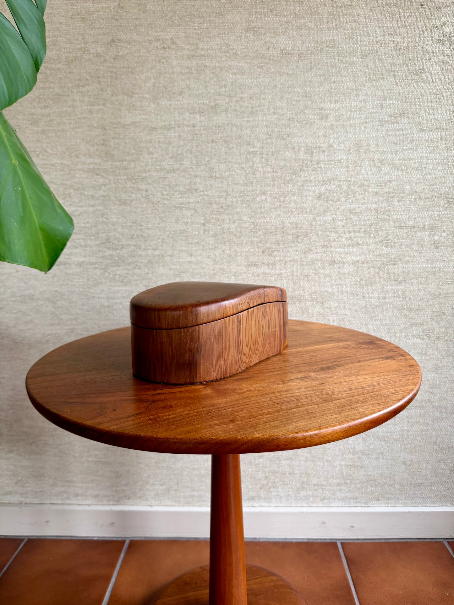Wooden side table with a matching wooden box against a textured wall.