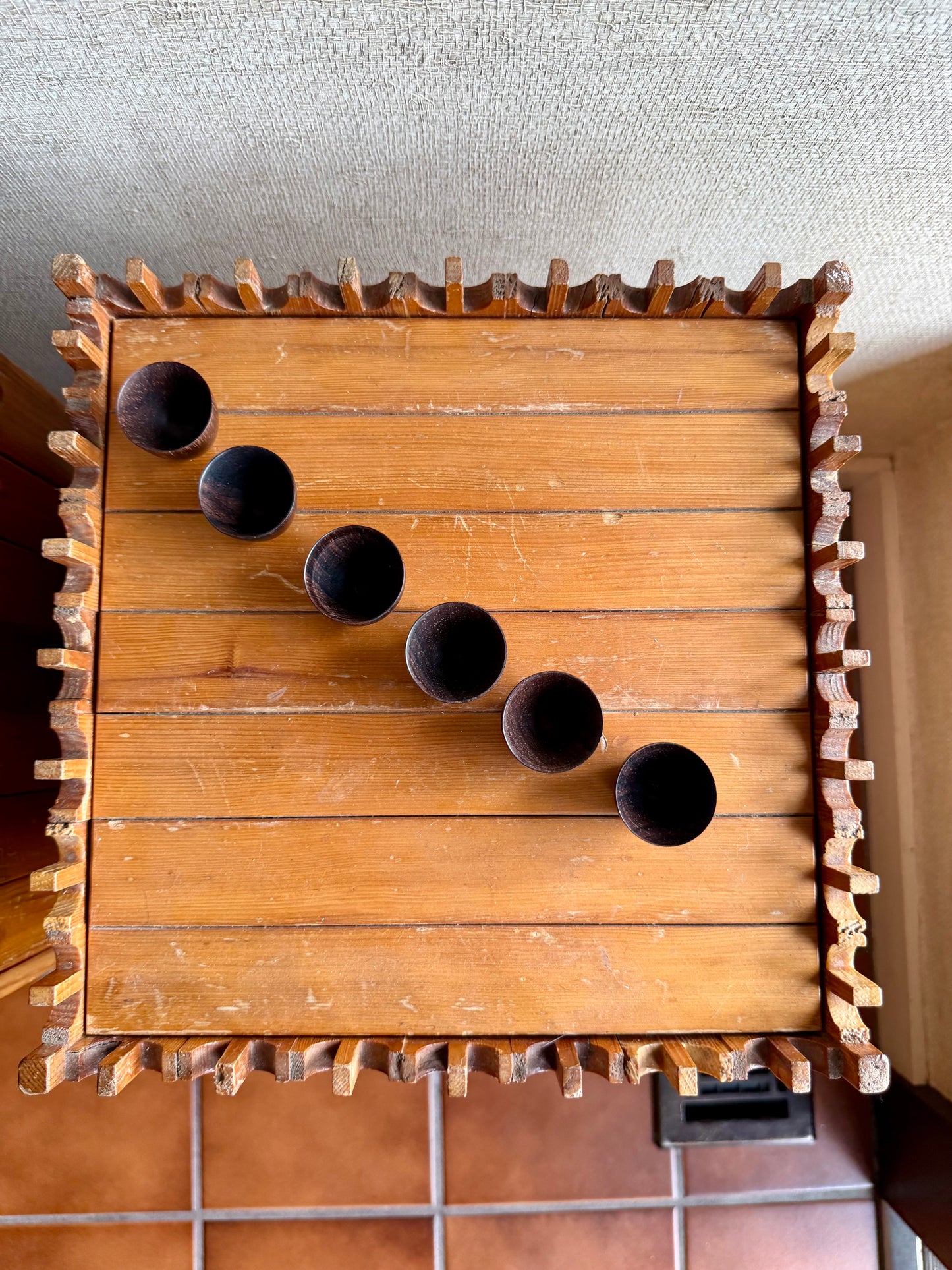Wooden wall-mounted shelf with circular holes and decorative edges