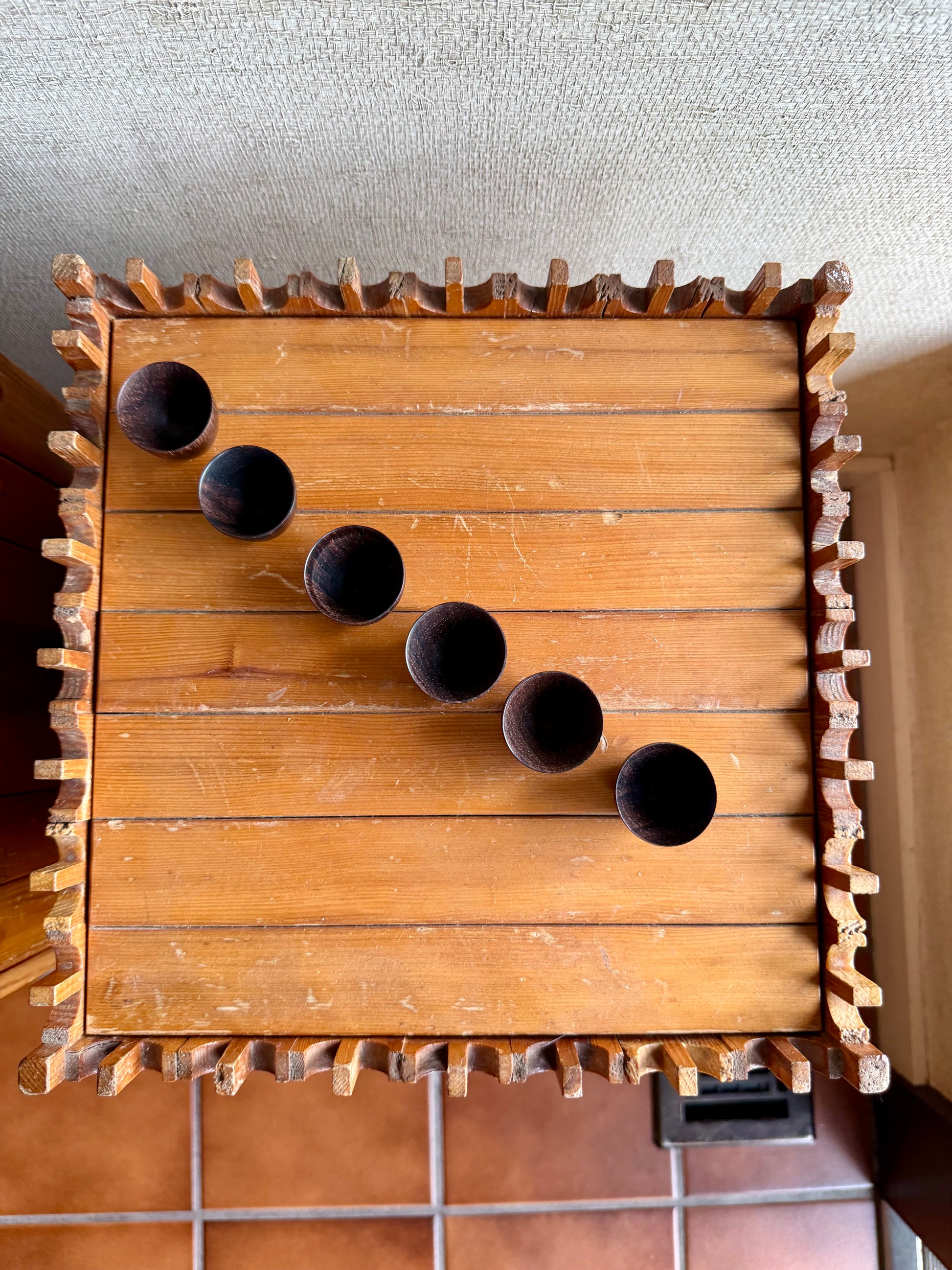 Wooden wall-mounted shelf with circular holes and decorative edges