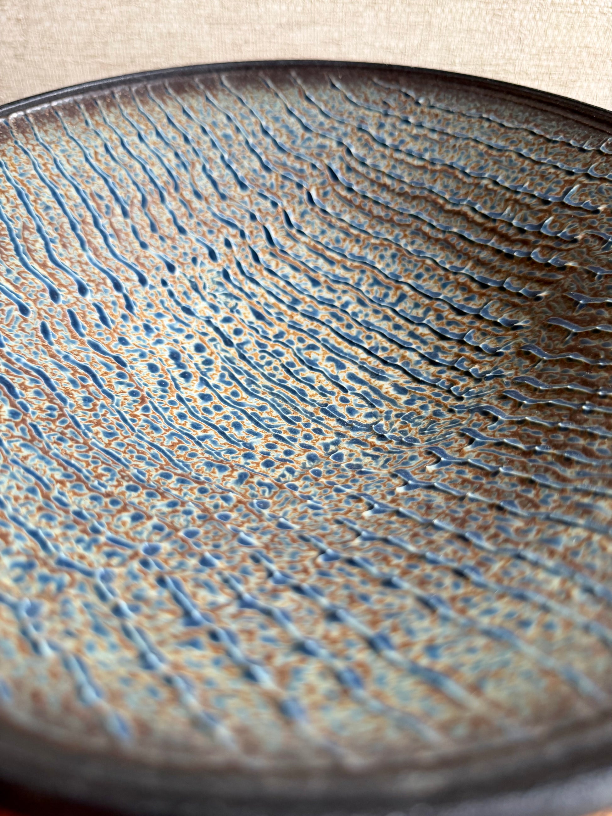 Close-up of a textured ceramic plate with wavy patterns