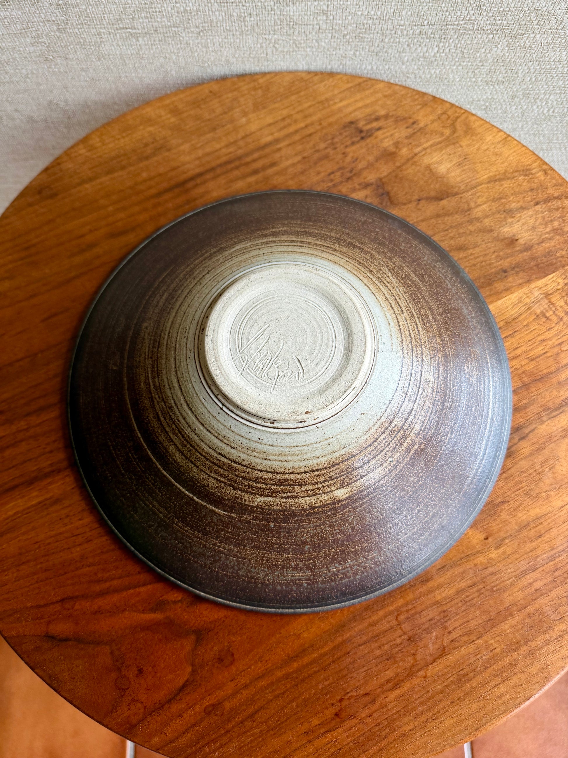 Stoneware bowl with a textured surface on a wooden surface