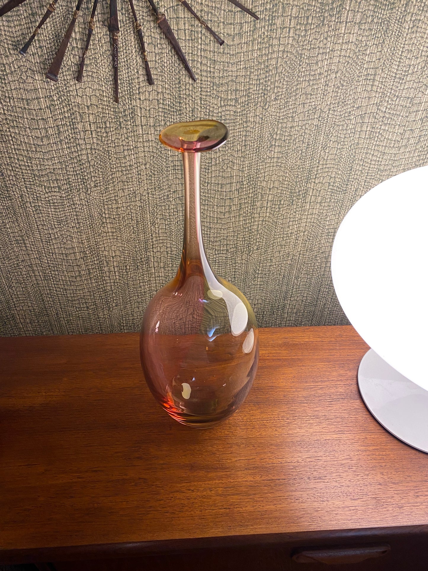 Glass wine decanter on a wooden surface with a textured fabric background