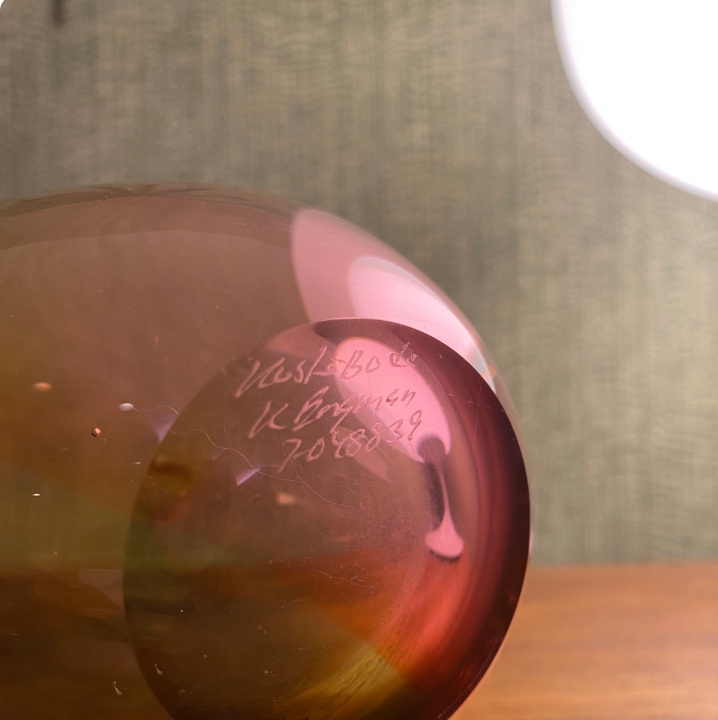 Glass object with engraved text on a wooden surface