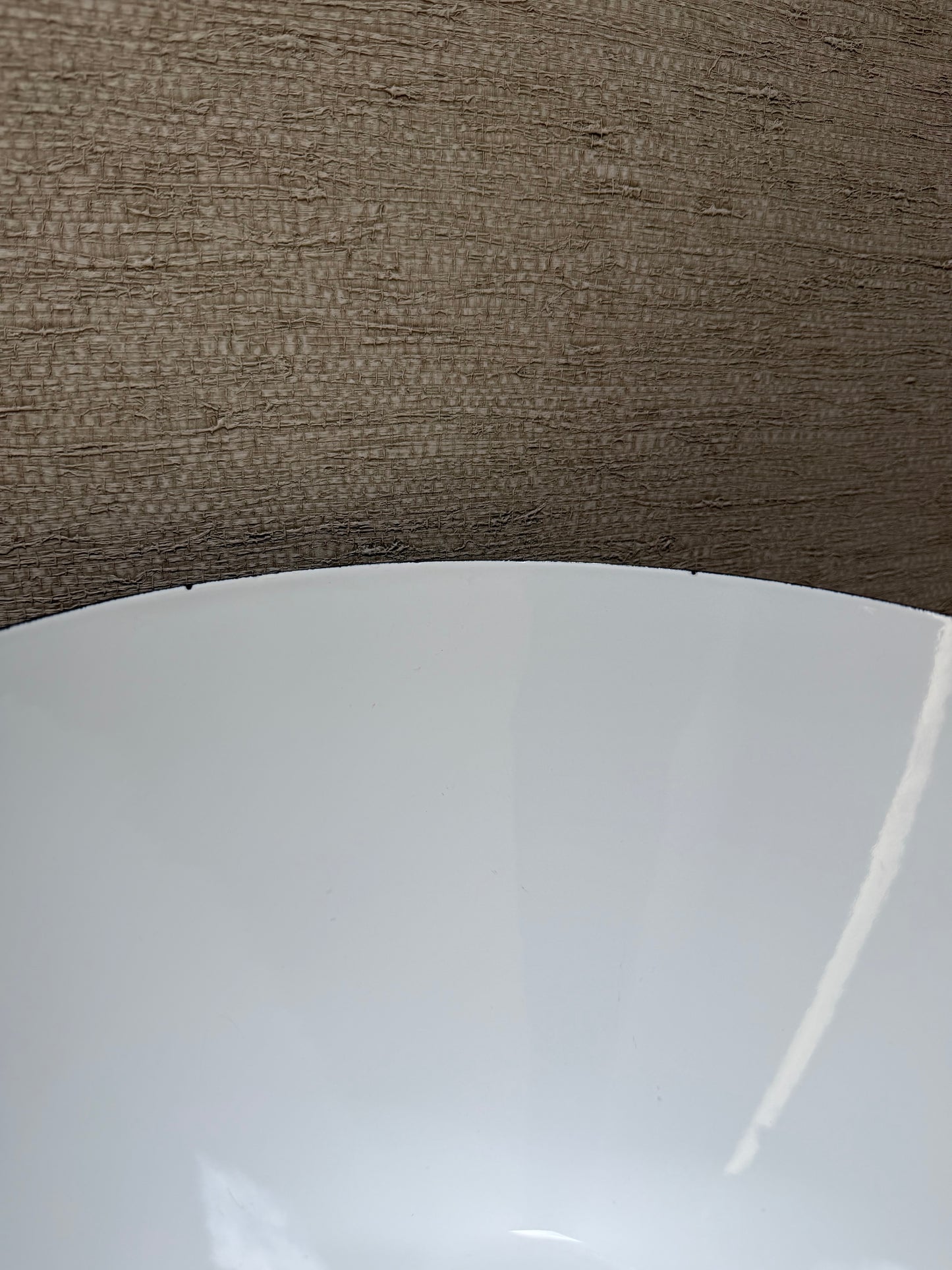 Close-up of a white bowl with a brown textured background