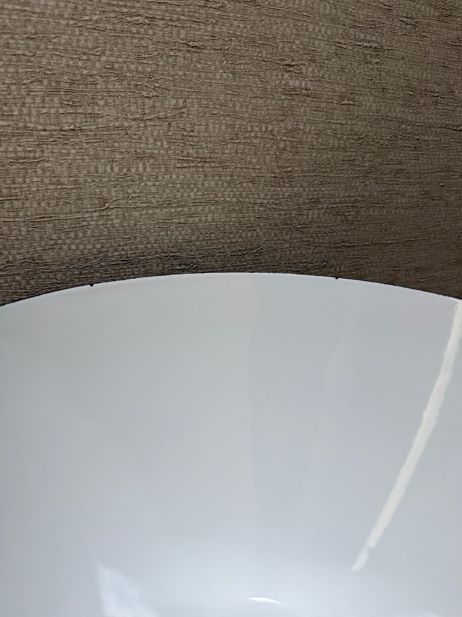 Close-up of a white bowl with a brown textured background